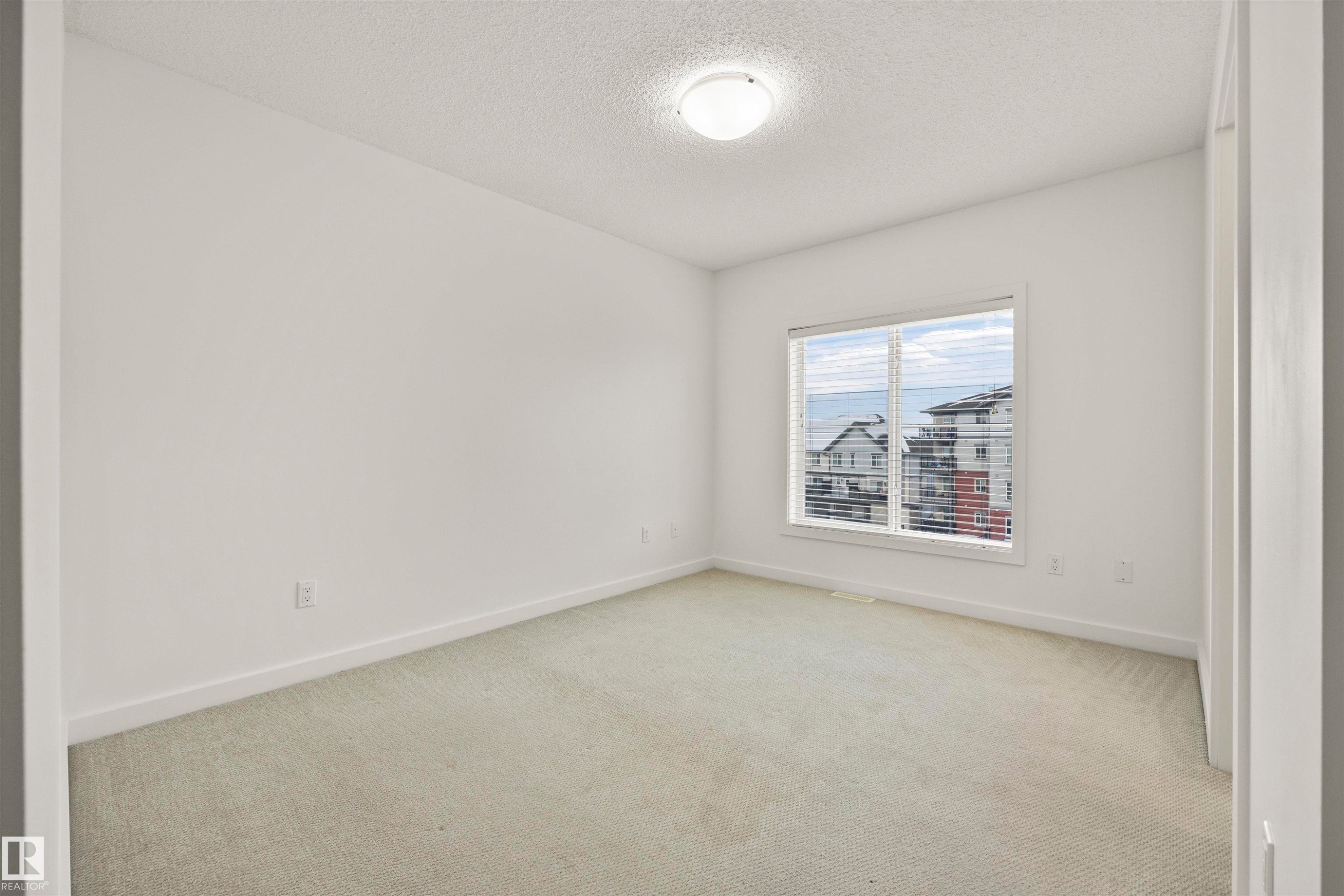 Carpeted spare room with a textured ceiling and baseboards - 56 655 Watt Boulevard, Edmonton, AB - Indoor Photo Showing Other Room
