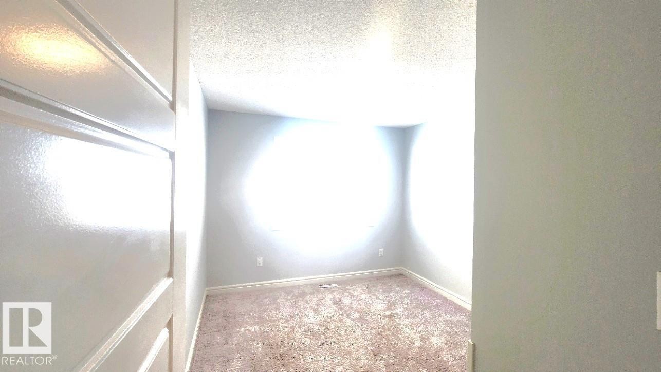 Empty room with carpet flooring and a textured ceiling - 4610 Kinsella Landing Sw, Edmonton, AB - Indoor Photo Showing Other Room