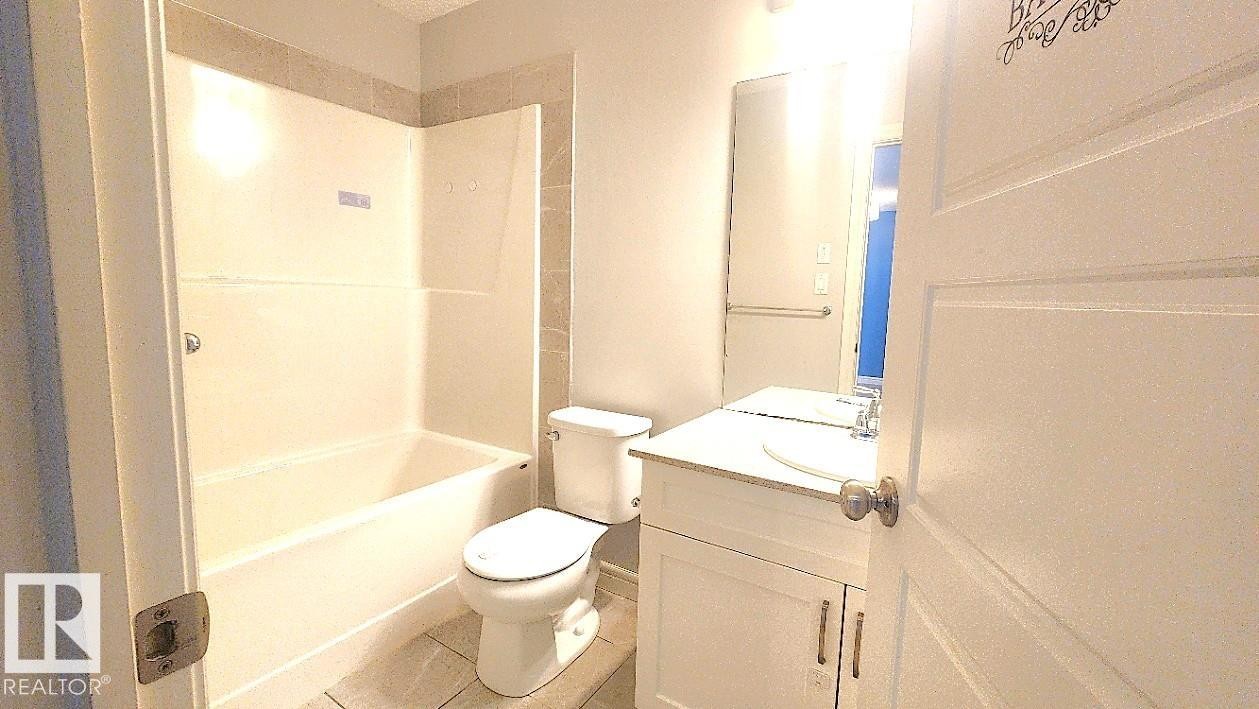 Full bathroom featuring vanity, shower combination, and light tile patterned floors - 4610 Kinsella Landing Sw, Edmonton, AB - Indoor Photo Showing Bathroom