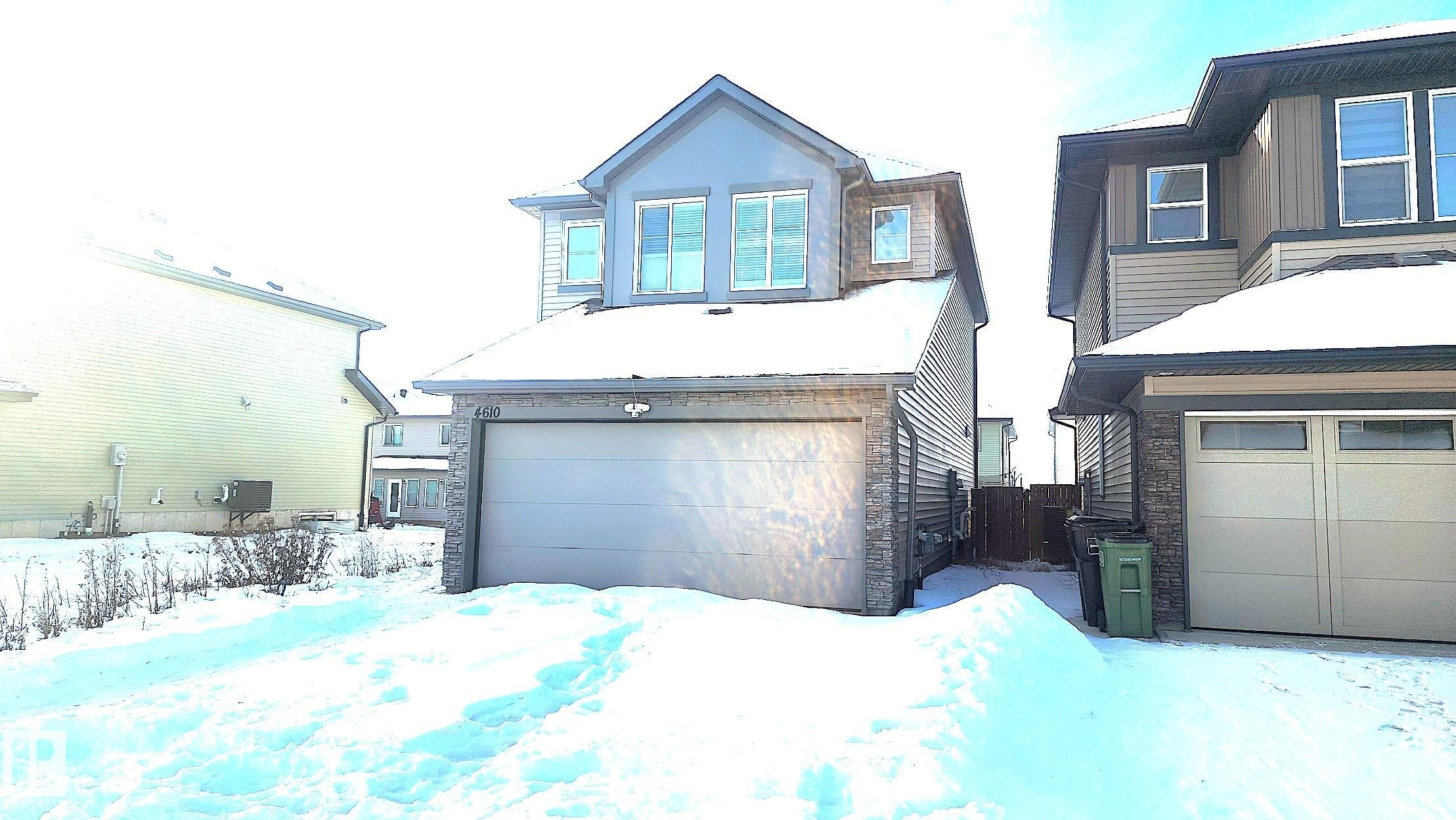 View of front facade with stone siding and a garage - 4610 Kinsella Landing Sw, Edmonton, AB - Outdoor