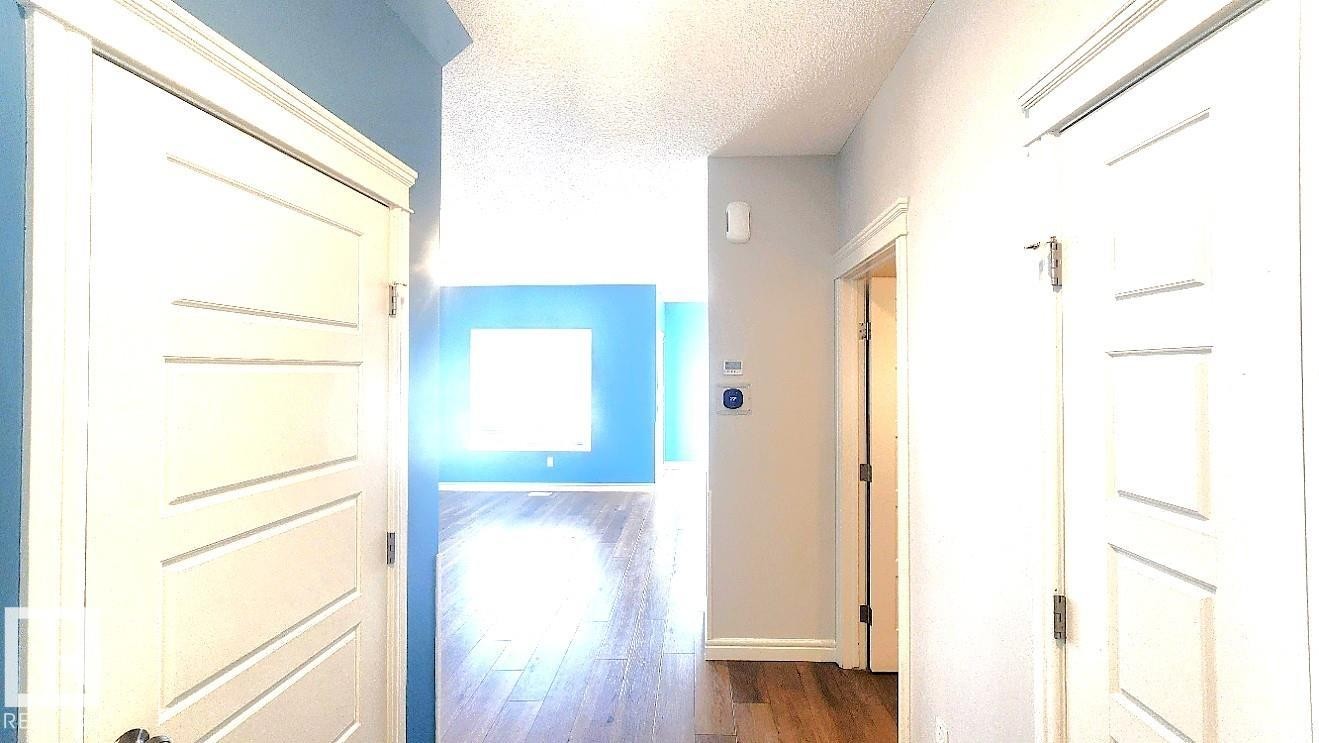 Hall featuring dark wood finished floors and a textured ceiling - 4610 Kinsella Landing Sw, Edmonton, AB - Indoor Photo Showing Other Room