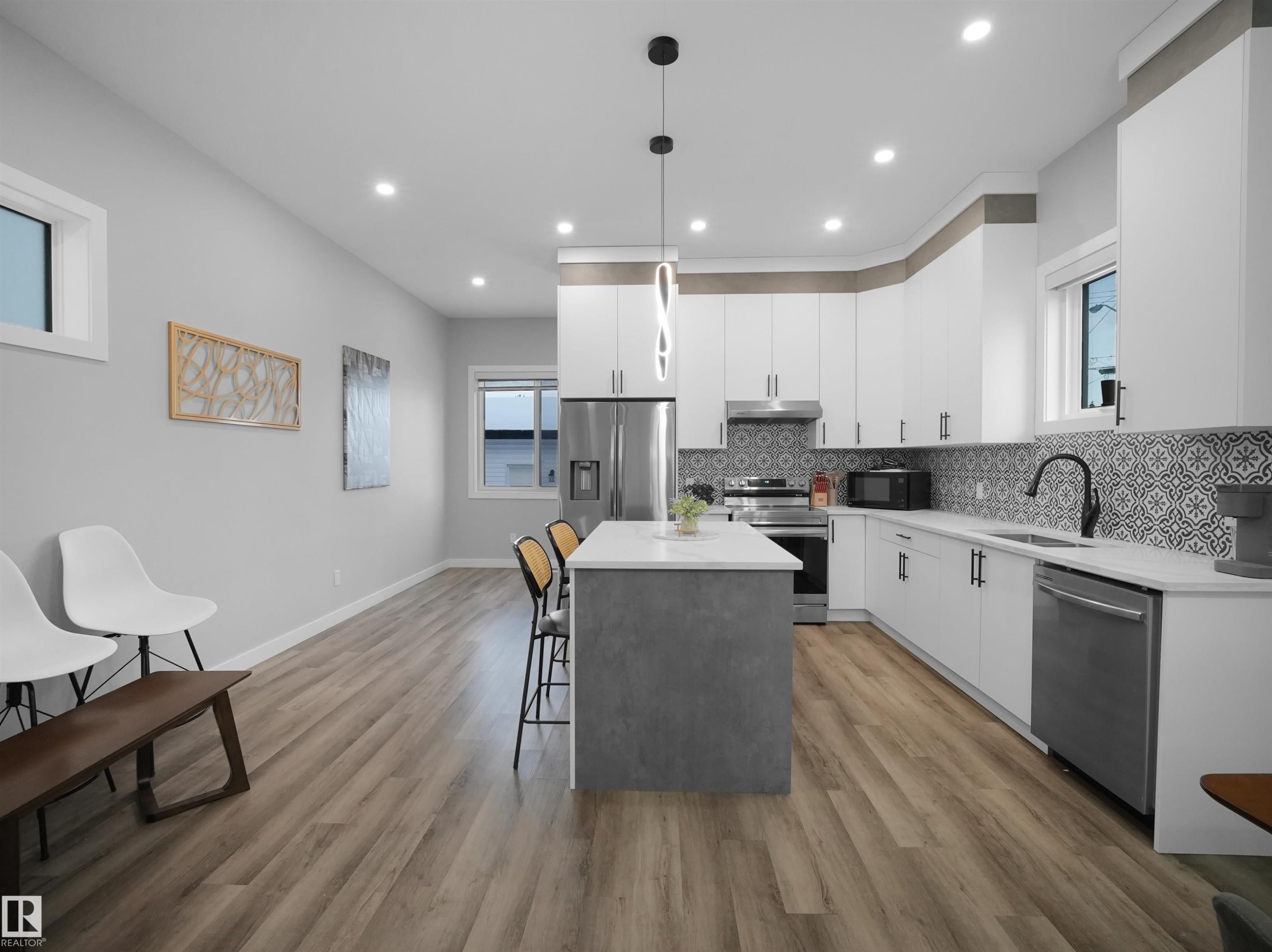 Kitchen with white cabinets, decorative light fixtures, stainless steel appliances, a center island, and recessed lighting - 10911 159 Street, Edmonton, AB - Indoor Photo Showing Kitchen With Upgraded Kitchen