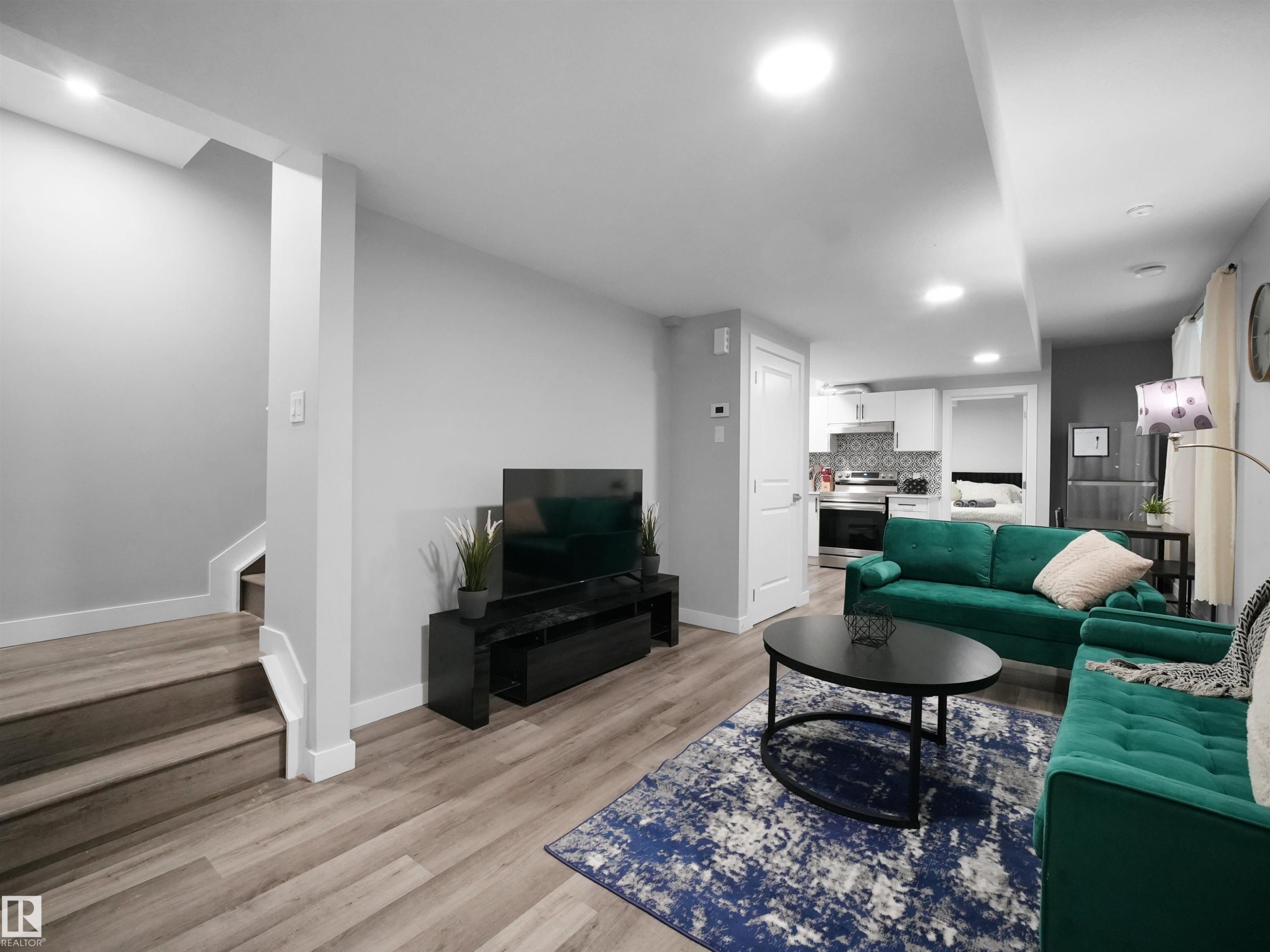Living room featuring light wood finished floors, recessed lighting, and stairway - 10911 159 Street, Edmonton, AB - Indoor Photo Showing Living Room