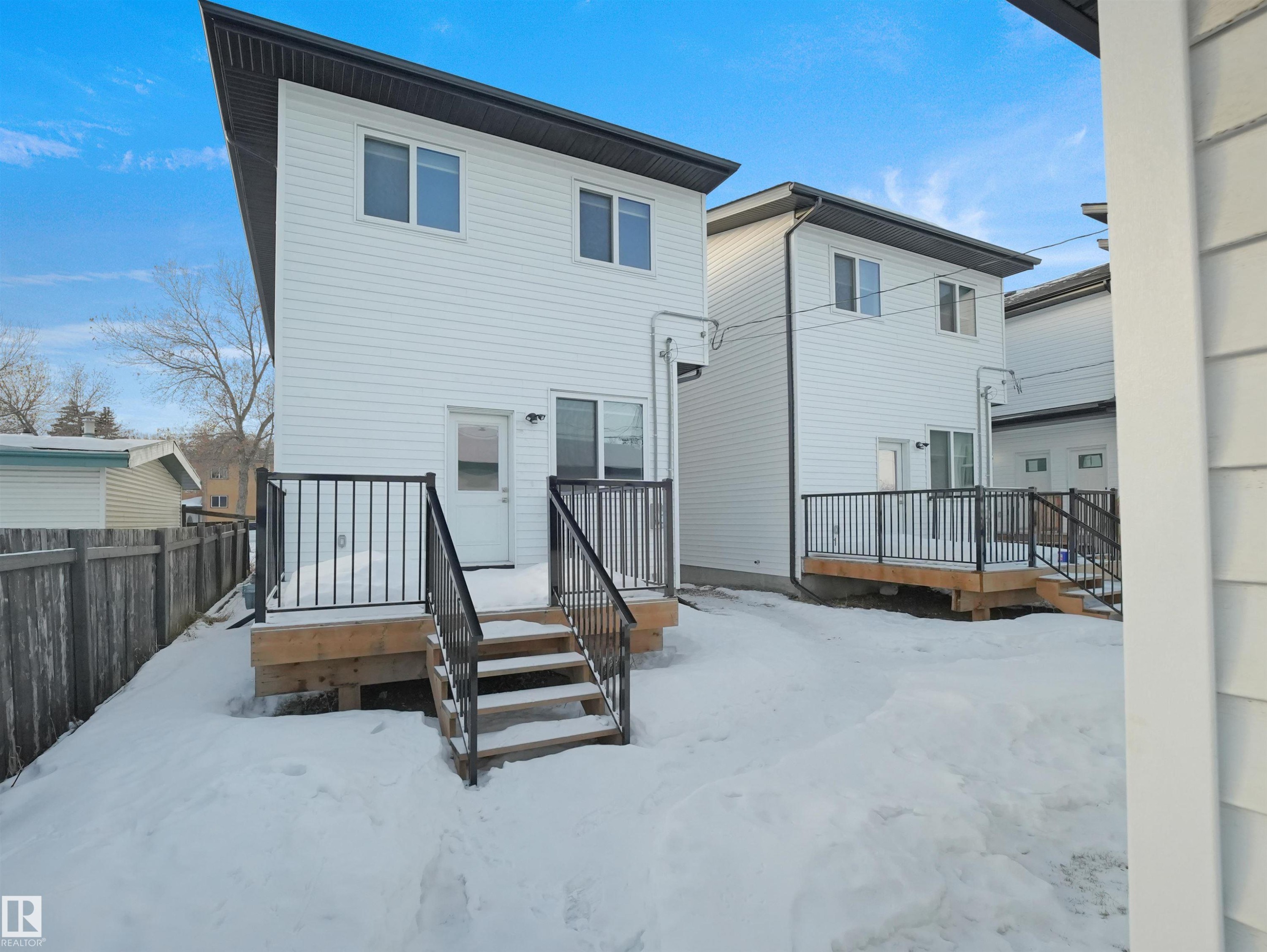 Snow covered house with a wooden deck - 10911 159 Street, Edmonton, AB - Outdoor With Exterior