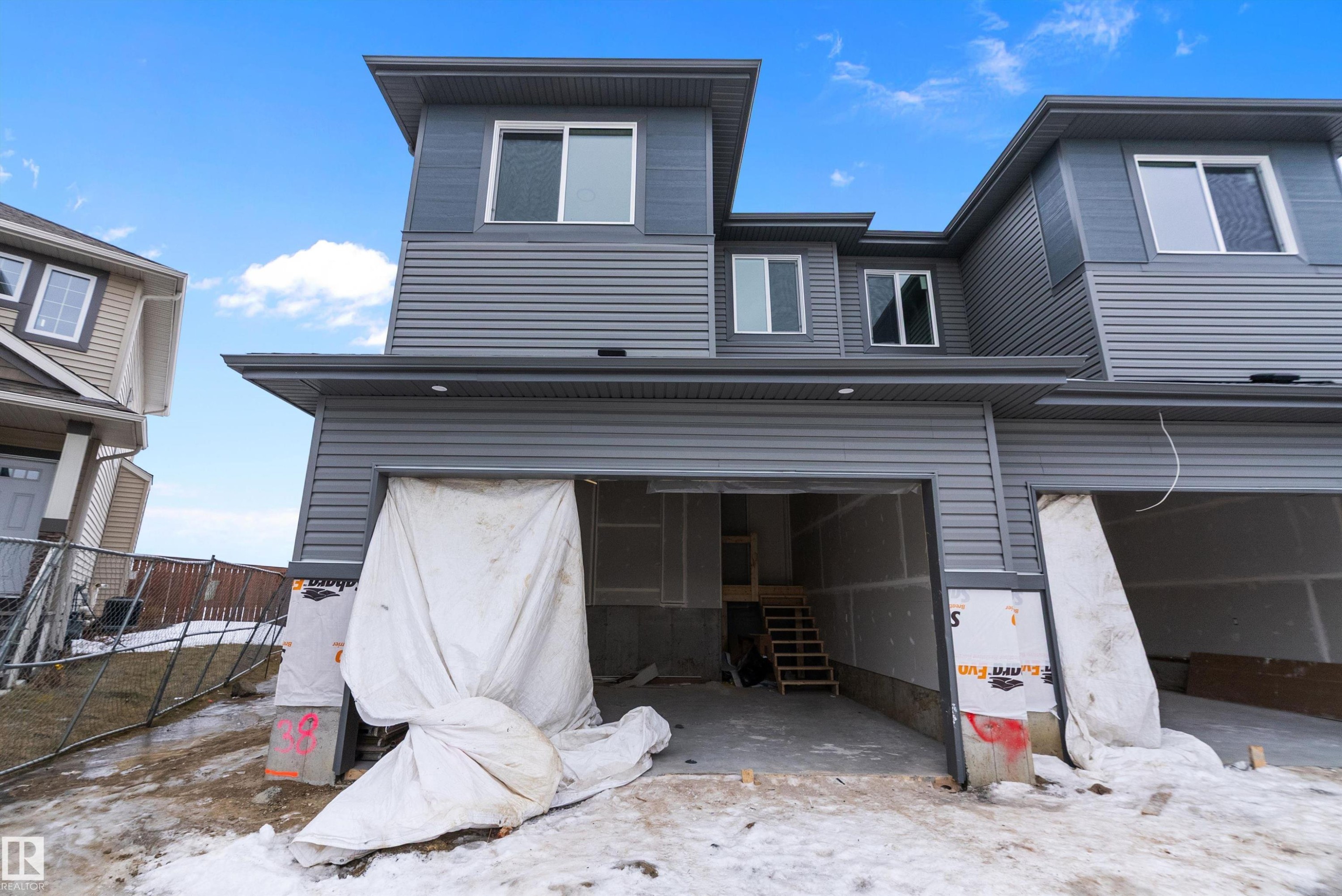 Snow covered back of property featuring a garage - 38 Astoria Place, Devon, AB - Outdoor