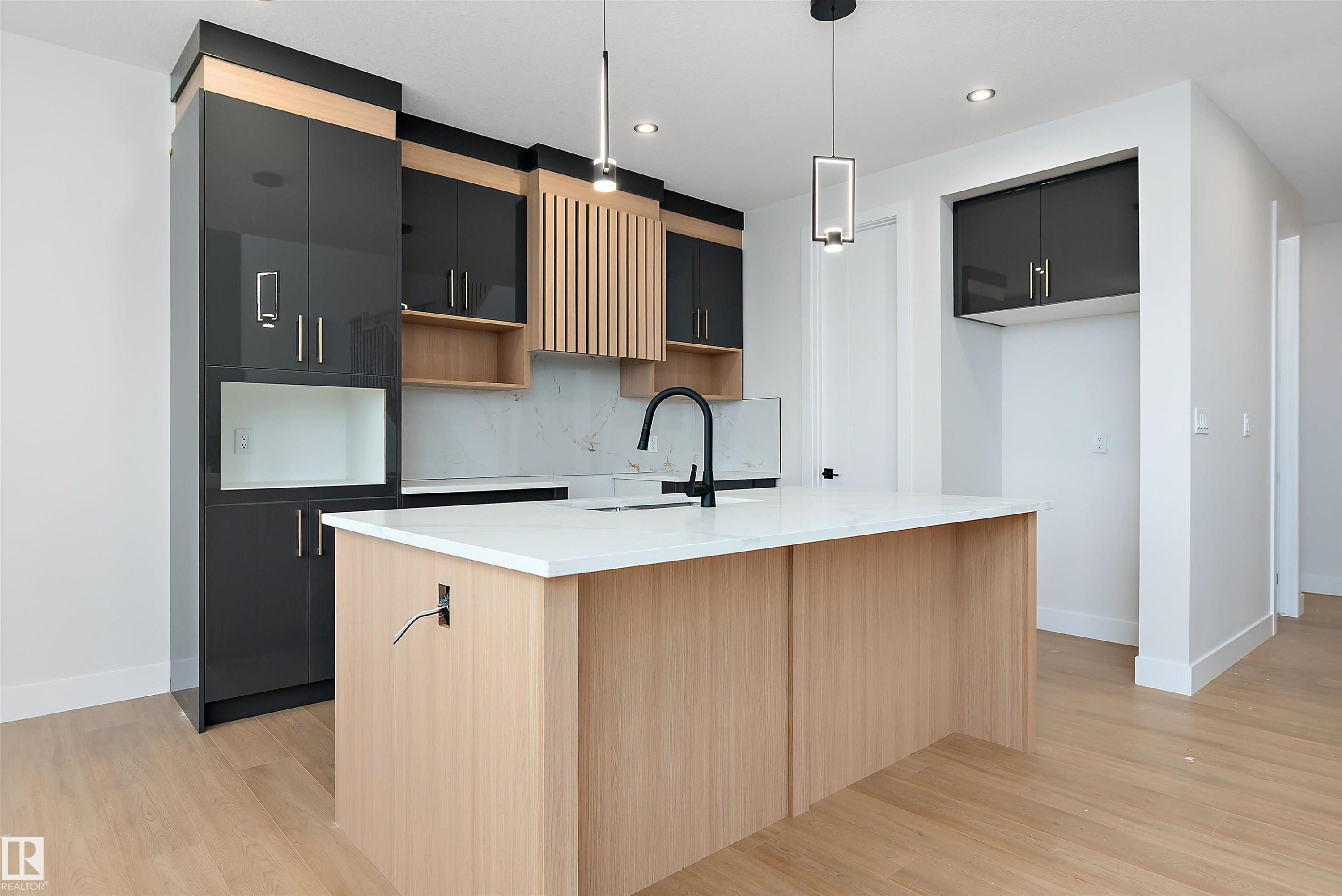 Kitchen featuring hanging light fixtures, light stone countertops, dark cabinets, and recessed lighting - 38 Astoria Place, Devon, AB - Indoor Photo Showing Kitchen
