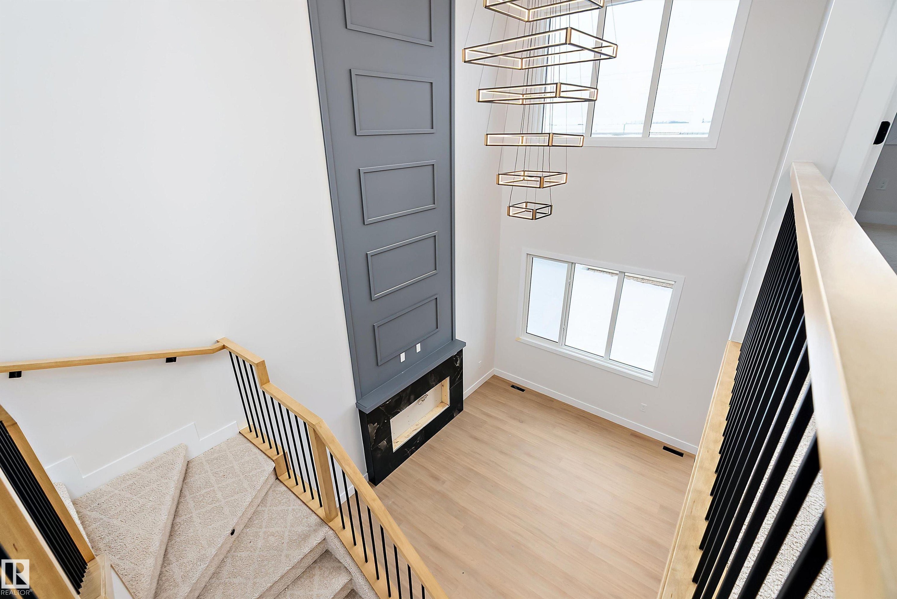 Staircase featuring a towering ceiling and wood finished floors - 38 Astoria Place, Devon, AB - Indoor Photo Showing Other Room