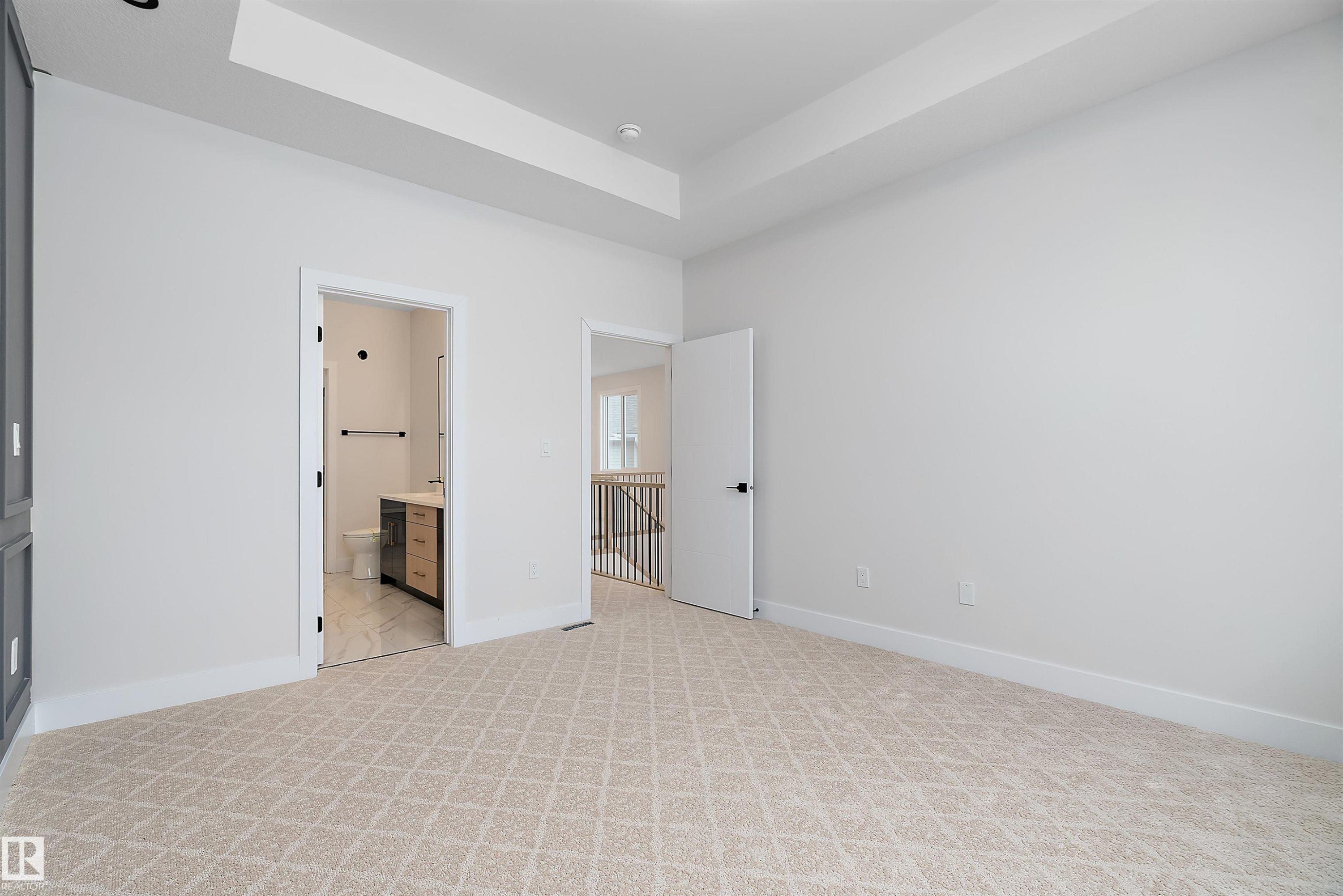 Unfurnished bedroom with light carpet, a raised ceiling, and connected bathroom - 38 Astoria Place, Devon, AB - Indoor Photo Showing Other Room