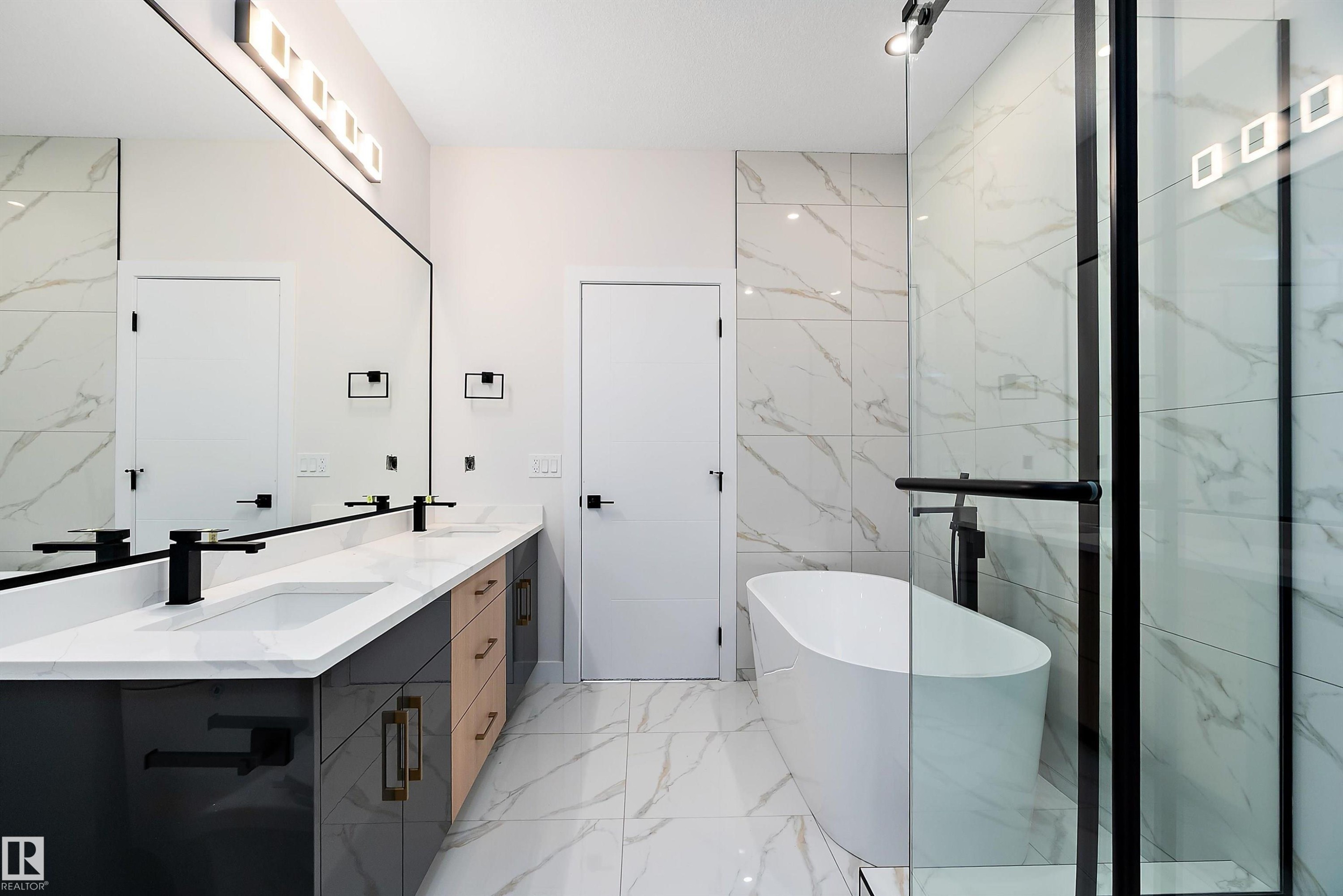 Bathroom with a freestanding tub, light marble finish floors, double vanity, and tile walls - 38 Astoria Place, Devon, AB - Indoor Photo Showing Bathroom