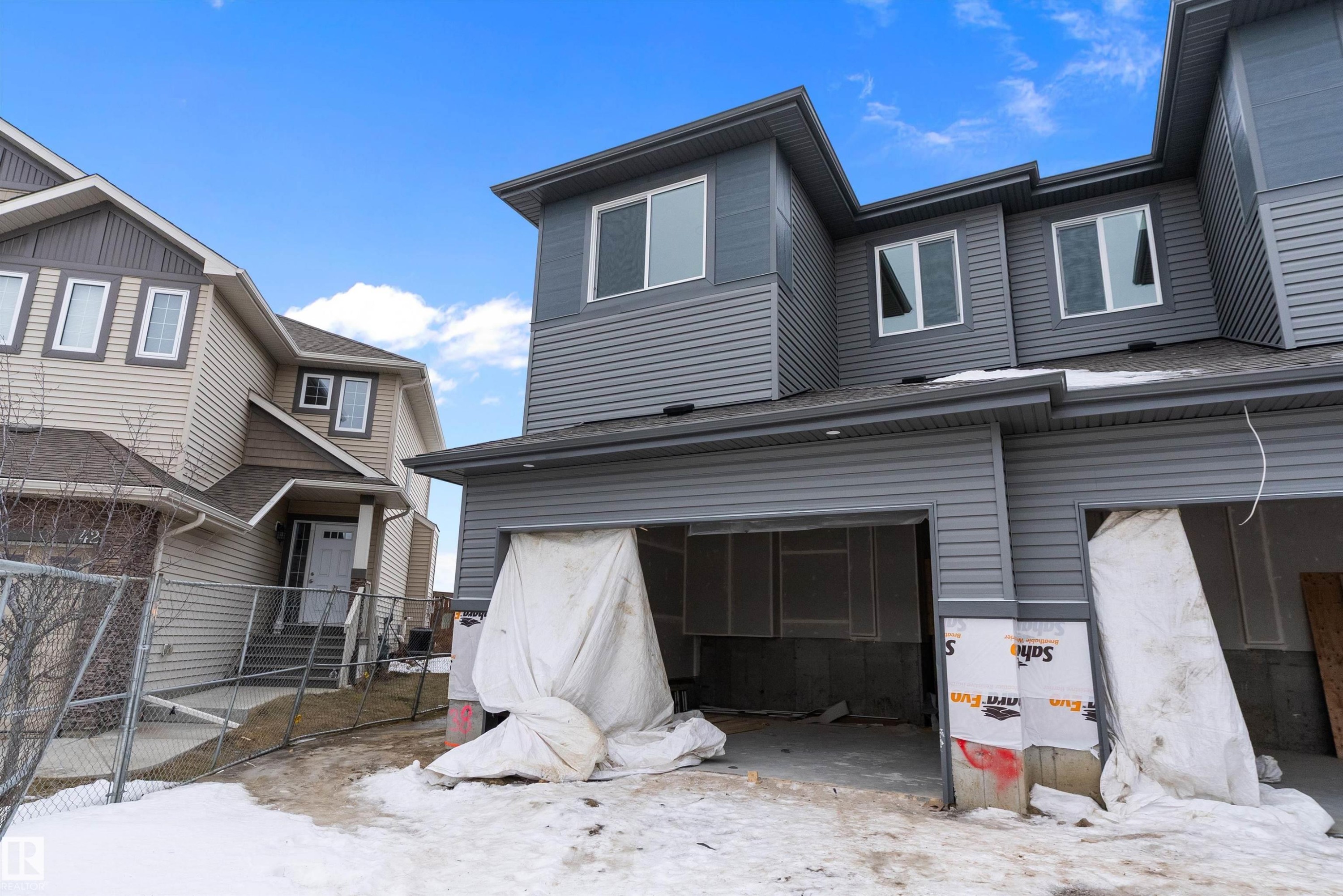 Snow covered back of property with a garage - 38 Astoria Place, Devon, AB - Outdoor