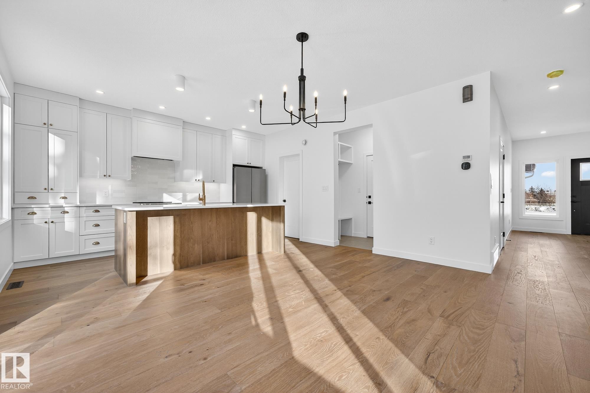 Kitchen with white cabinets, an island with sink, light wood-style flooring, open floor plan, and recessed lighting - 132 Heron Point Close, Rural Wetaskiwin County, AB - Indoor Photo Showing Kitchen With Upgraded Kitchen