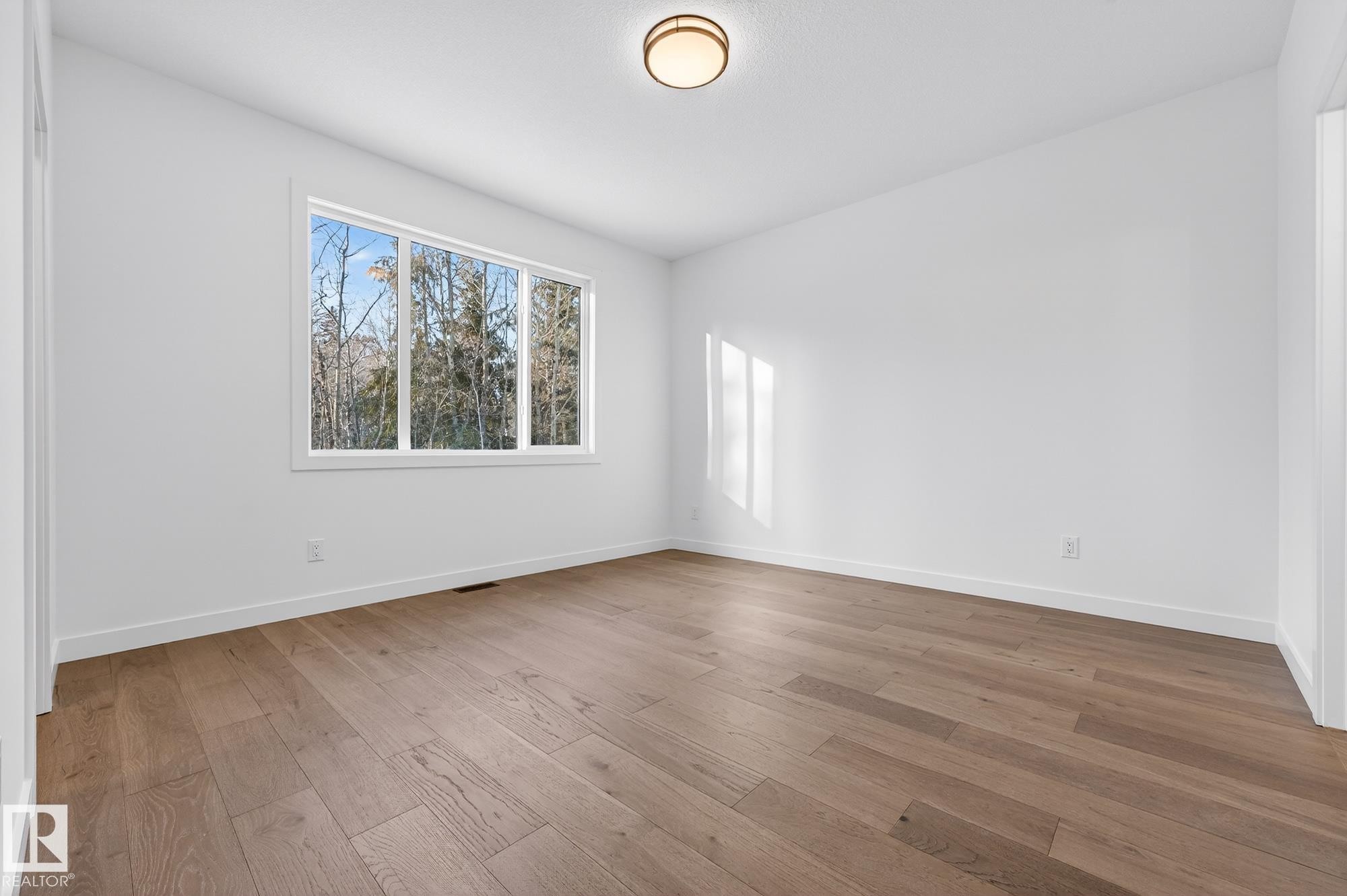 Unfurnished room with hardwood / wood-style flooring and baseboards - 132 Heron Point Close, Rural Wetaskiwin County, AB - Indoor Photo Showing Other Room