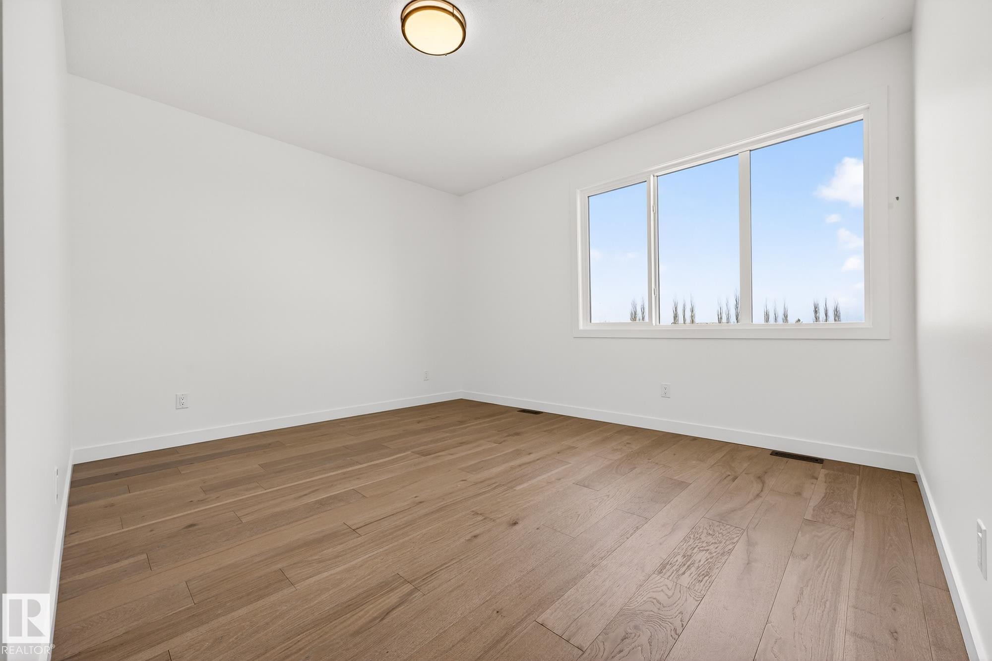 Unfurnished room featuring light wood finished floors and baseboards - 132 Heron Point Close, Rural Wetaskiwin County, AB - Indoor Photo Showing Other Room