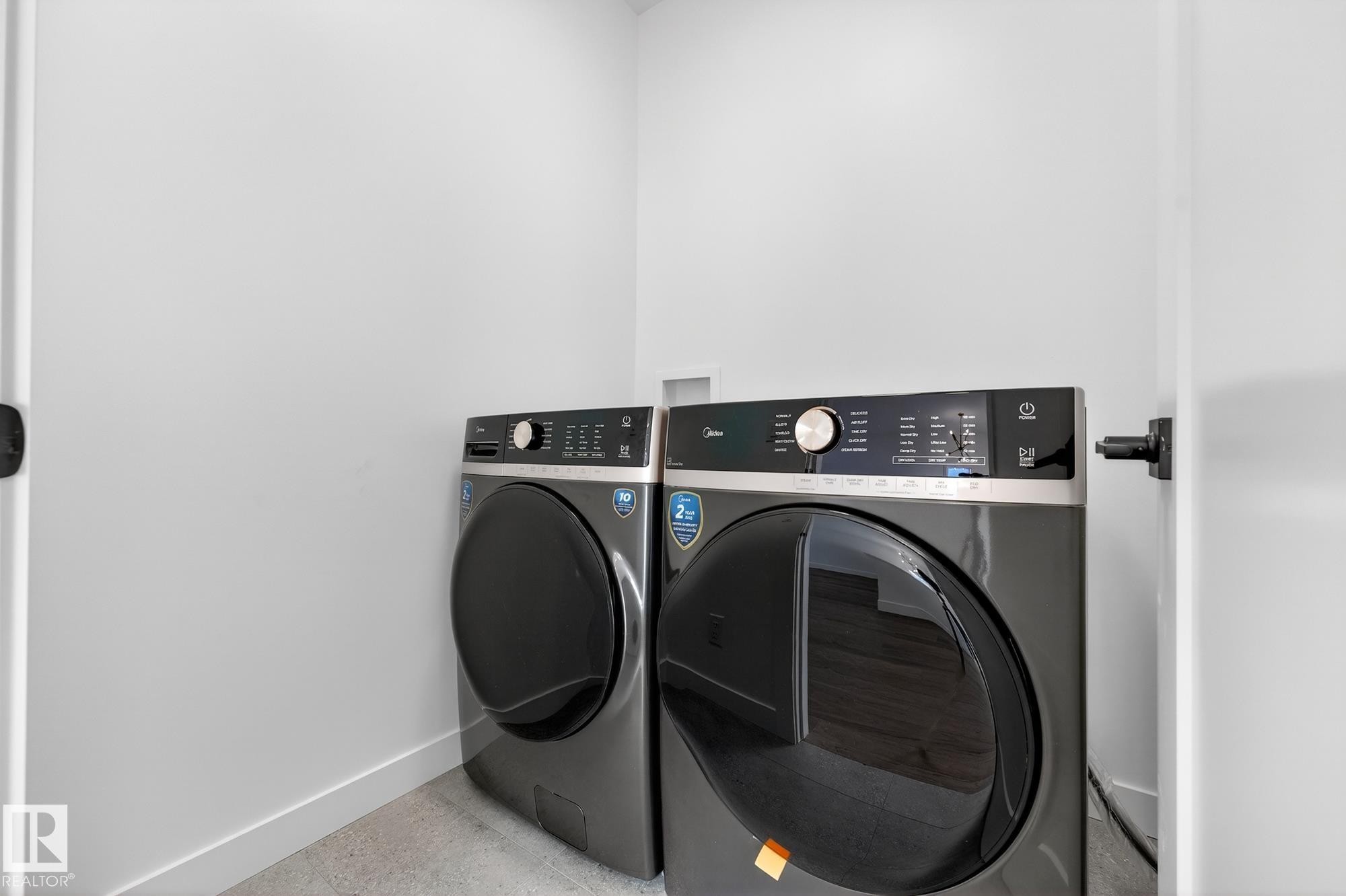 Laundry area featuring baseboards and washer and clothes dryer - 132 Heron Point Close, Rural Wetaskiwin County, AB - Indoor Photo Showing Laundry Room