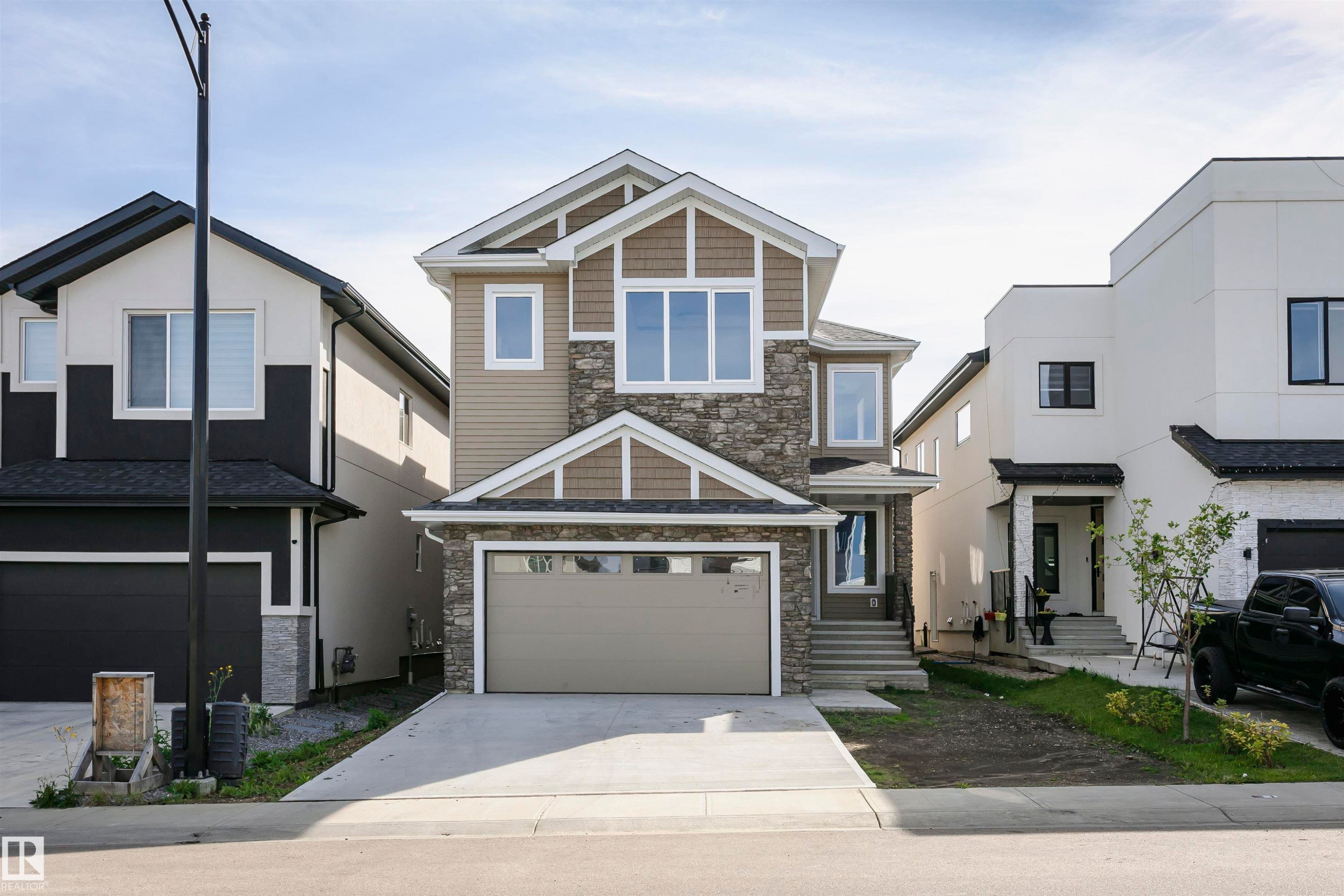 Craftsman inspired home featuring stone siding, concrete driveway, and a garage - 1723 19 Street, Edmonton, AB - Outdoor With Facade