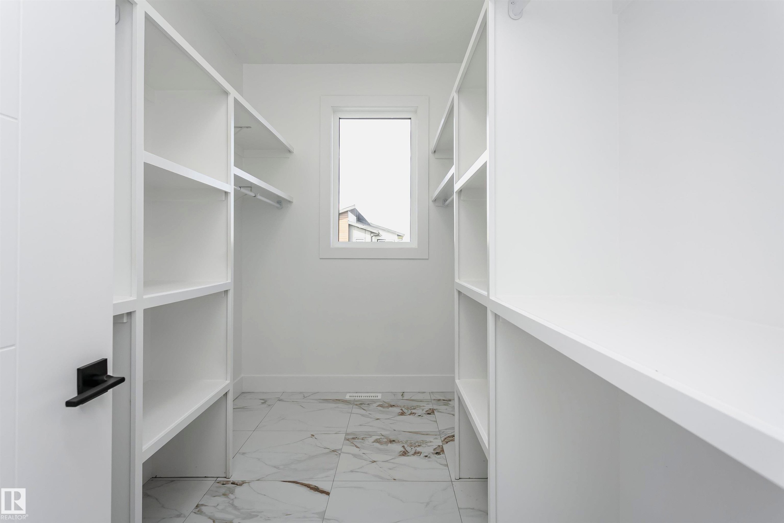 Walk in closet featuring light marble finish floors - 1723 19 Street, Edmonton, AB - Indoor With Storage