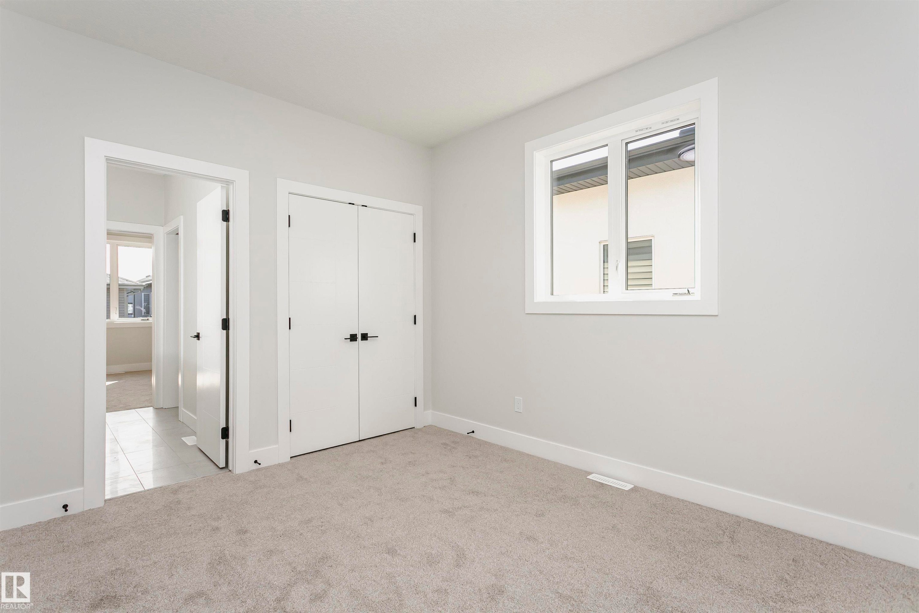 Unfurnished bedroom featuring light colored carpet and a closet - 1723 19 Street, Edmonton, AB - Indoor Photo Showing Other Room