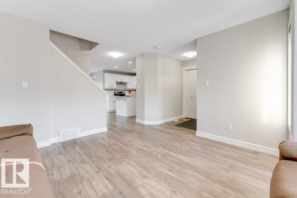 Unfurnished living room with light wood-type flooring and baseboards - 1423 24 Street, Edmonton, AB - Indoor