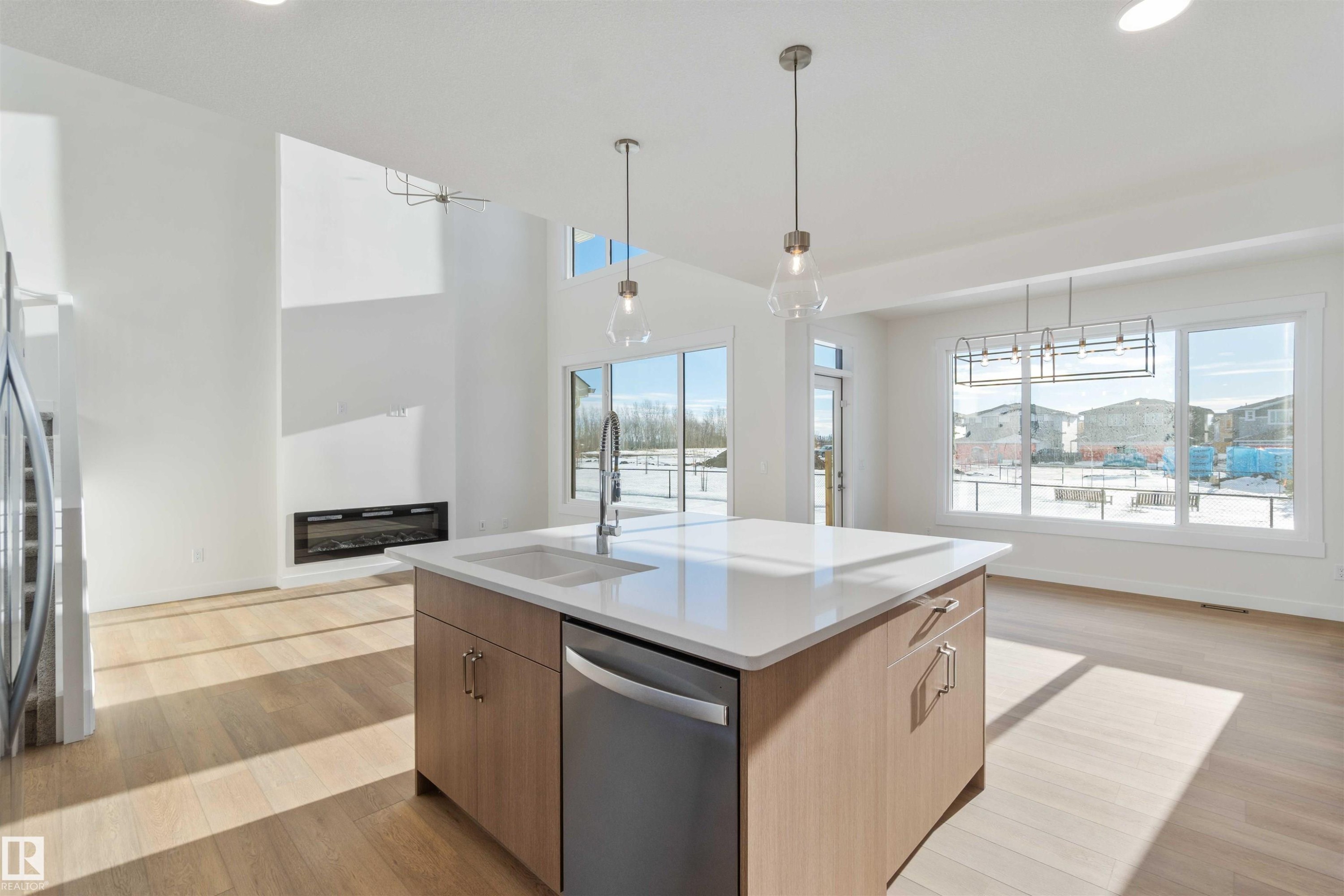 Kitchen with light wood-style floors, stainless steel appliances, pendant lighting, a kitchen island with sink, and recessed lighting - 2215 4 Avenue, Edmonton, AB - Indoor Photo Showing Kitchen