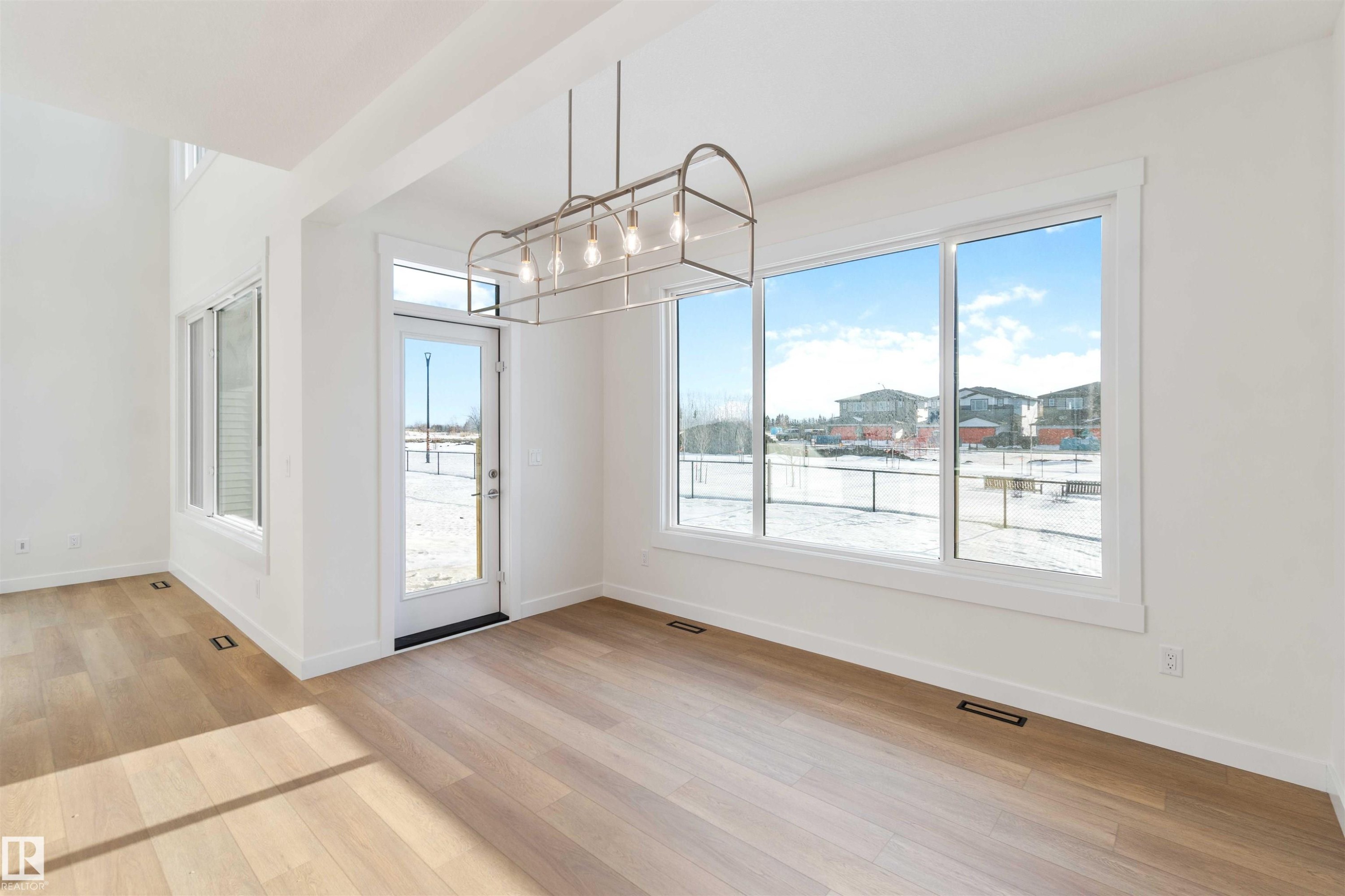 Unfurnished dining area featuring light wood finished floors and a chandelier - 2215 4 Avenue, Edmonton, AB - Indoor Photo Showing Other Room