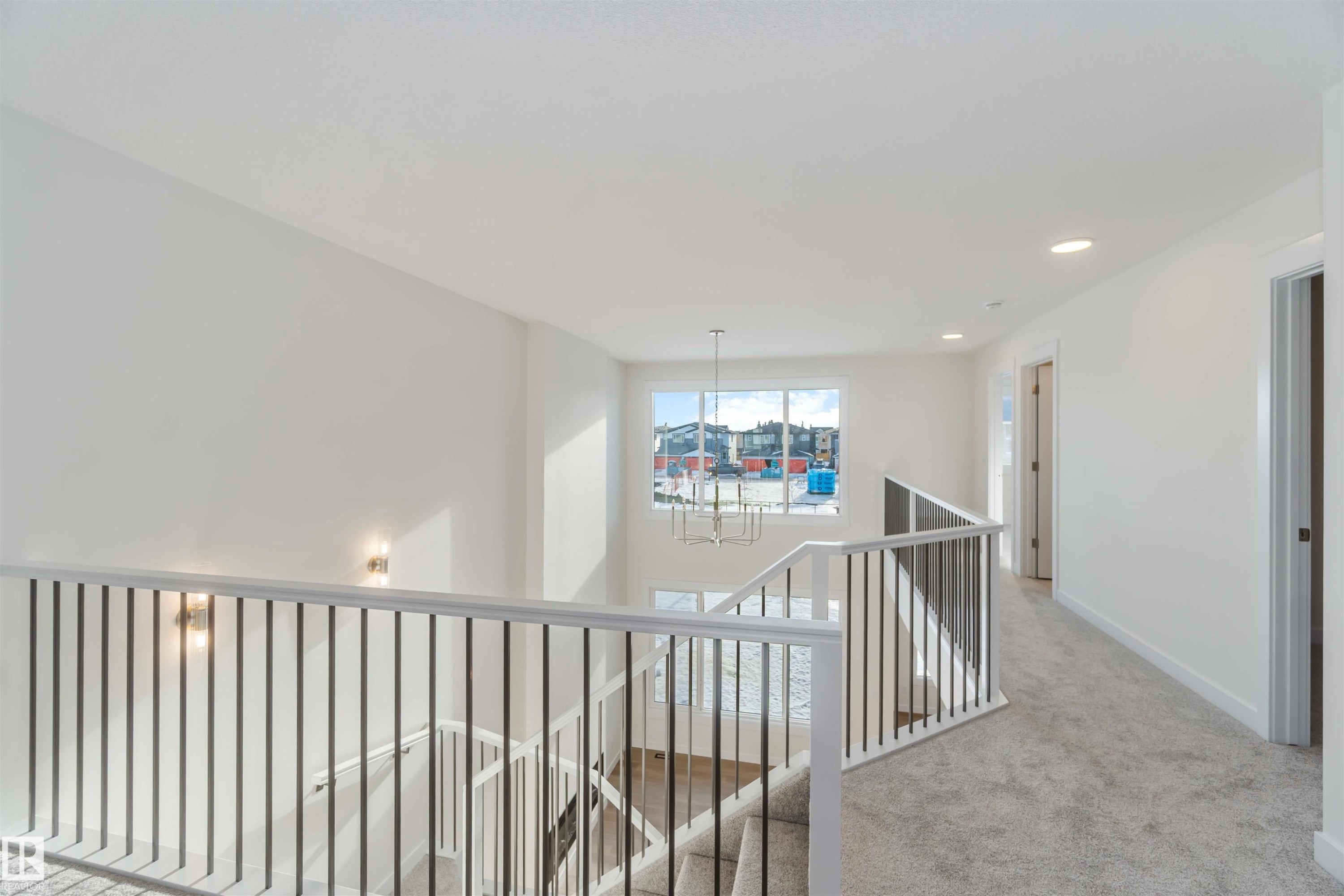 Hall with a chandelier, light colored carpet, an upstairs landing, and recessed lighting - 2215 4 Avenue, Edmonton, AB - Indoor Photo Showing Other Room