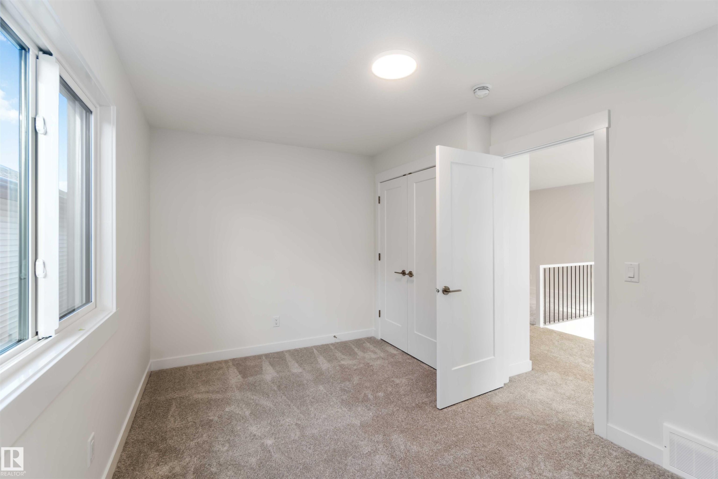 Unfurnished bedroom with light colored carpet and a closet - 2215 4 Avenue, Edmonton, AB - Indoor Photo Showing Other Room