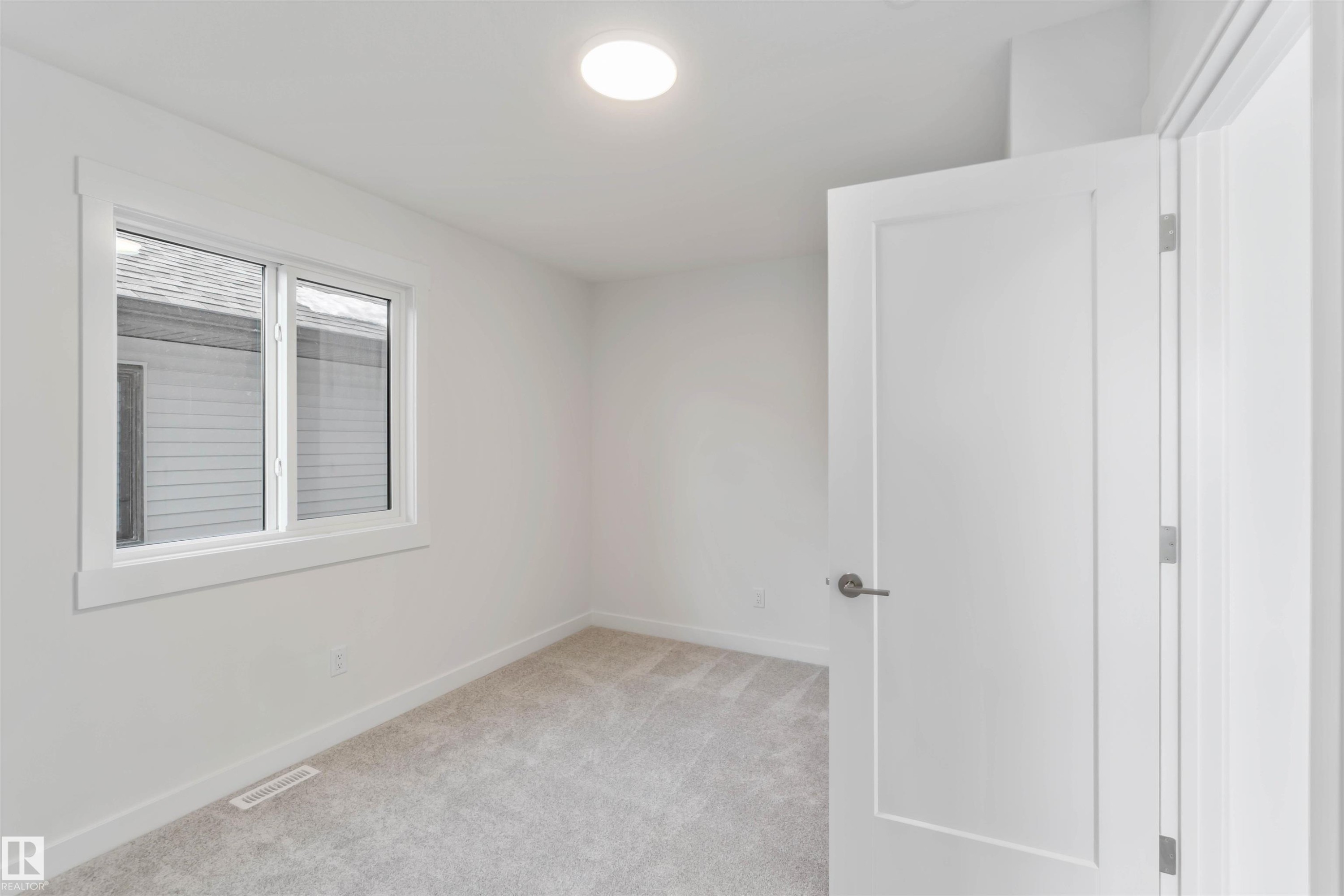 Empty room with light colored carpet and baseboards - 2215 4 Avenue, Edmonton, AB - Indoor Photo Showing Other Room