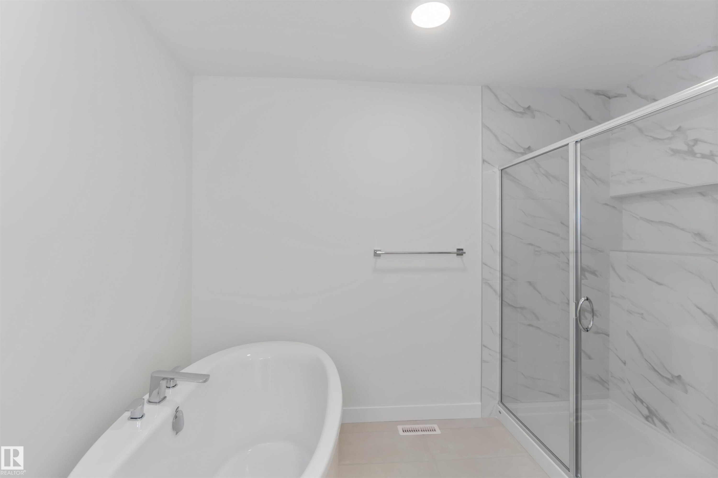 Full bathroom featuring a freestanding bath, a marble finish shower, and tile patterned flooring - 2215 4 Avenue, Edmonton, AB - Indoor Photo Showing Bathroom