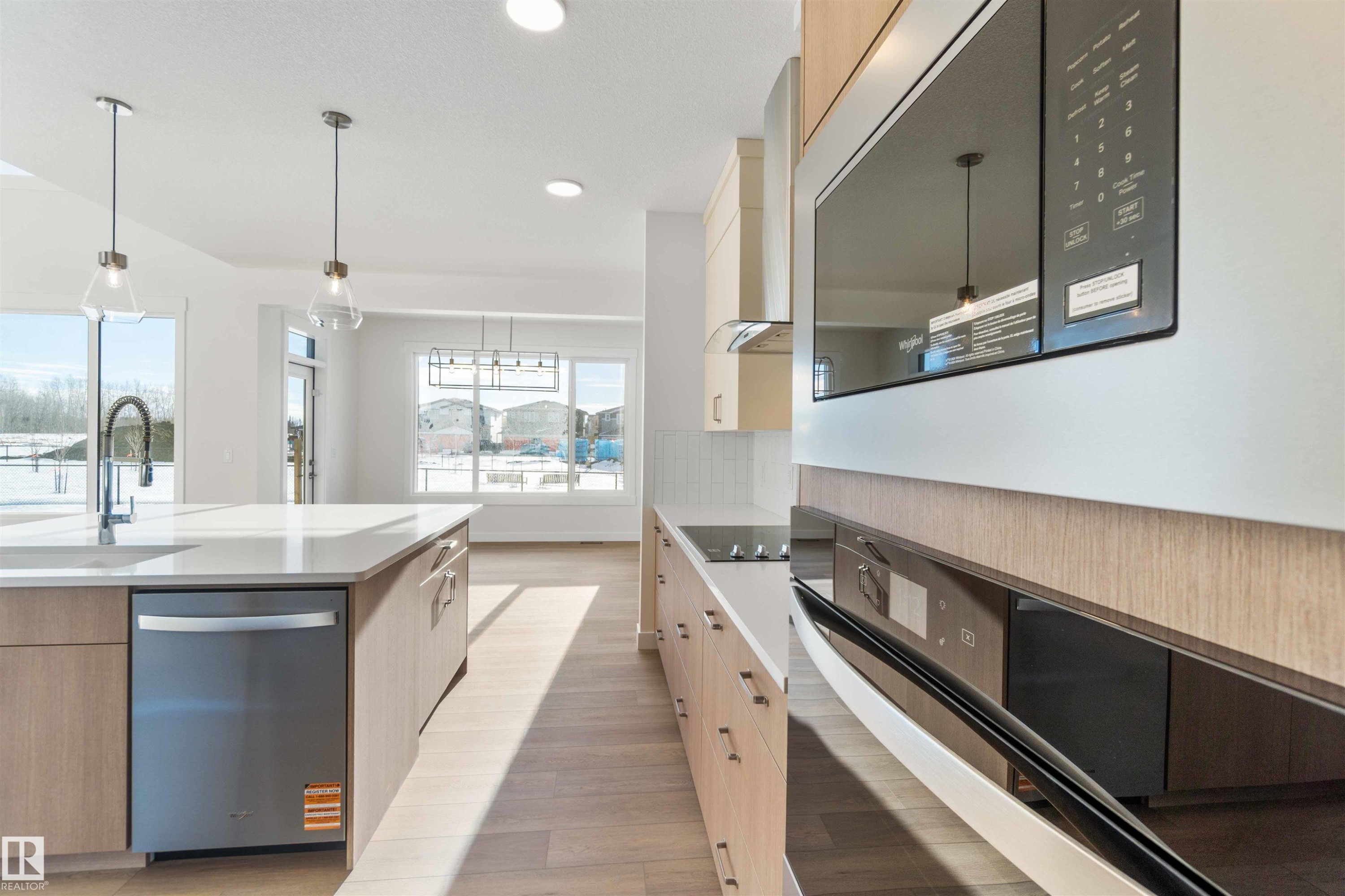 Kitchen with black appliances, modern cabinets, light brown cabinetry, decorative light fixtures, and recessed lighting - 2215 4 Avenue, Edmonton, AB - Indoor Photo Showing Kitchen With Upgraded Kitchen