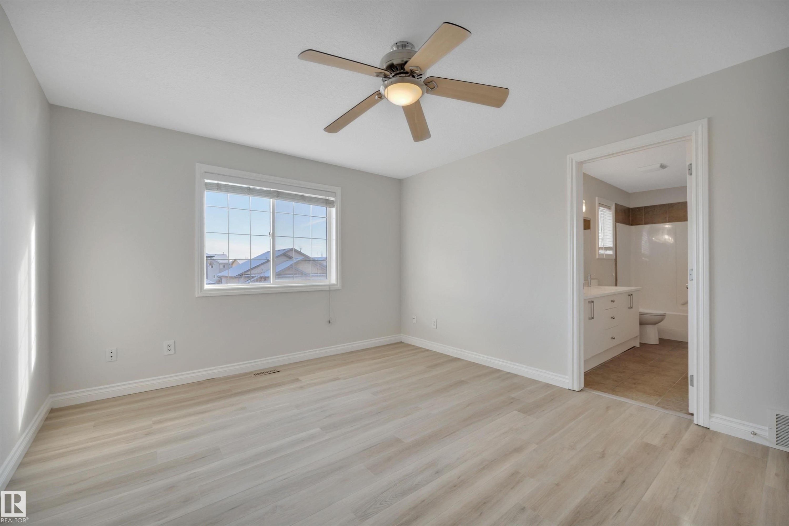 Unfurnished bedroom with light wood-type flooring, ceiling fan, and ensuite bathroom - 457 Aster Close, Leduc, AB - Indoor Photo Showing Other Room