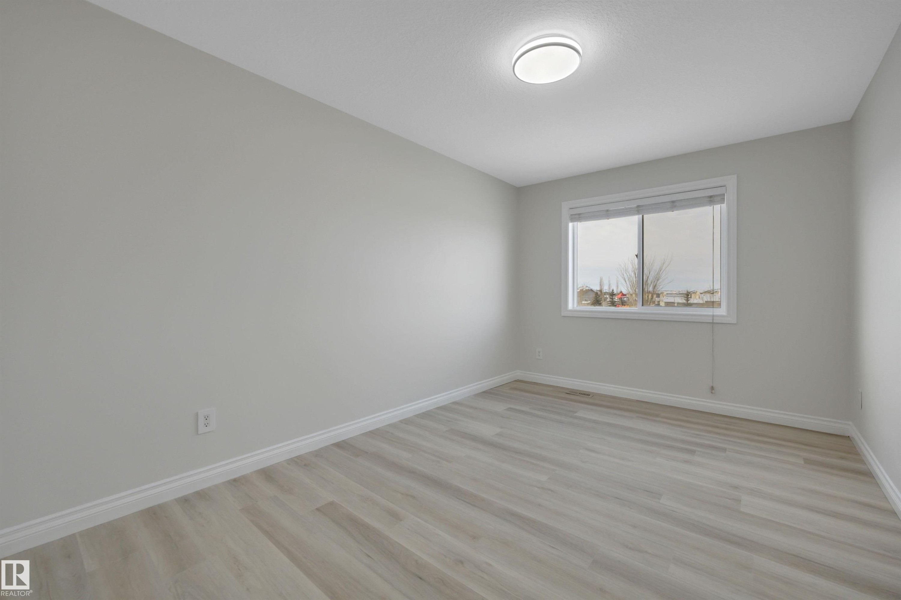 Unfurnished room featuring baseboards and light wood-style flooring - 457 Aster Close, Leduc, AB - Indoor Photo Showing Other Room