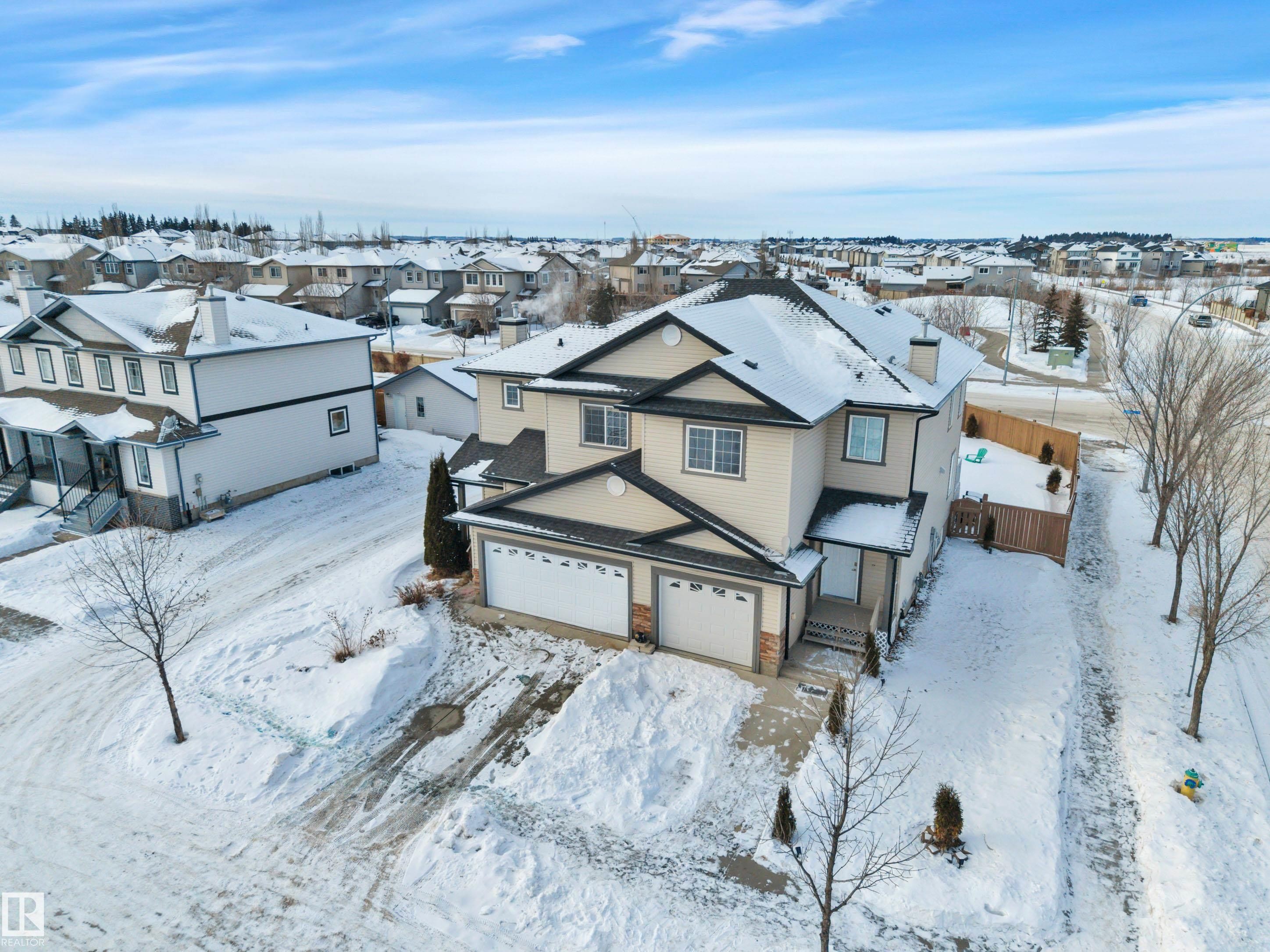Snowy aerial view featuring a residential view - 457 Aster Close, Leduc, AB - Outdoor With Facade