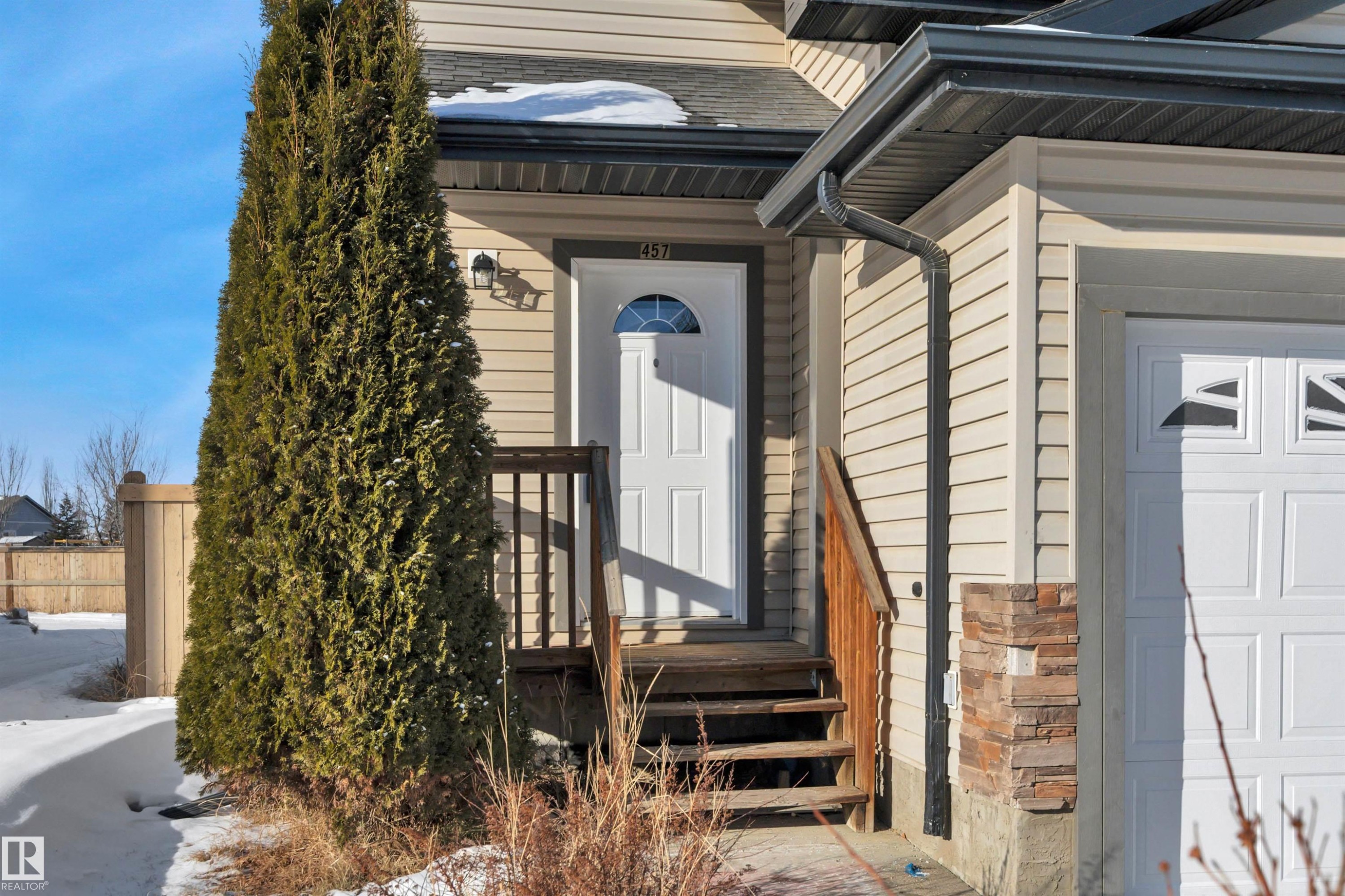 View of exterior entry with roof with shingles, a garage, and stone siding - 457 Aster Close, Leduc, AB - Outdoor