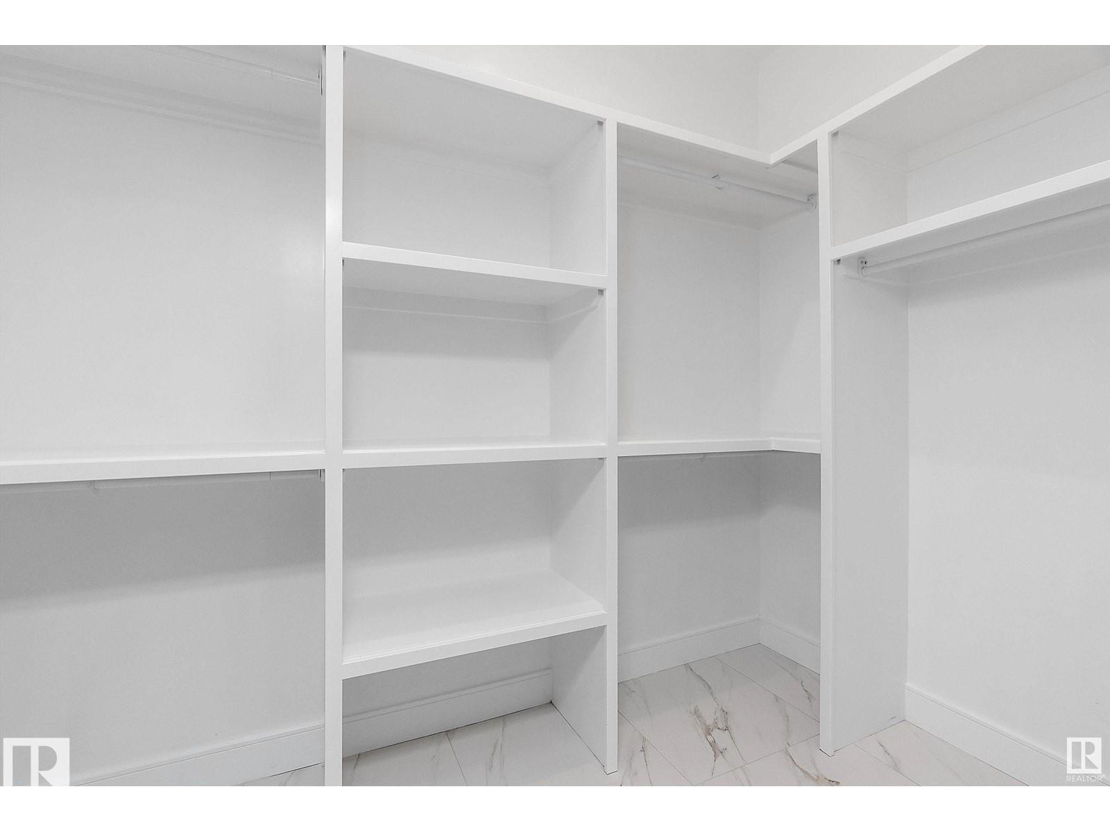 Walk in closet with light marble finish floors - 138 South Ravines Drive, Devon, AB - Indoor With Storage