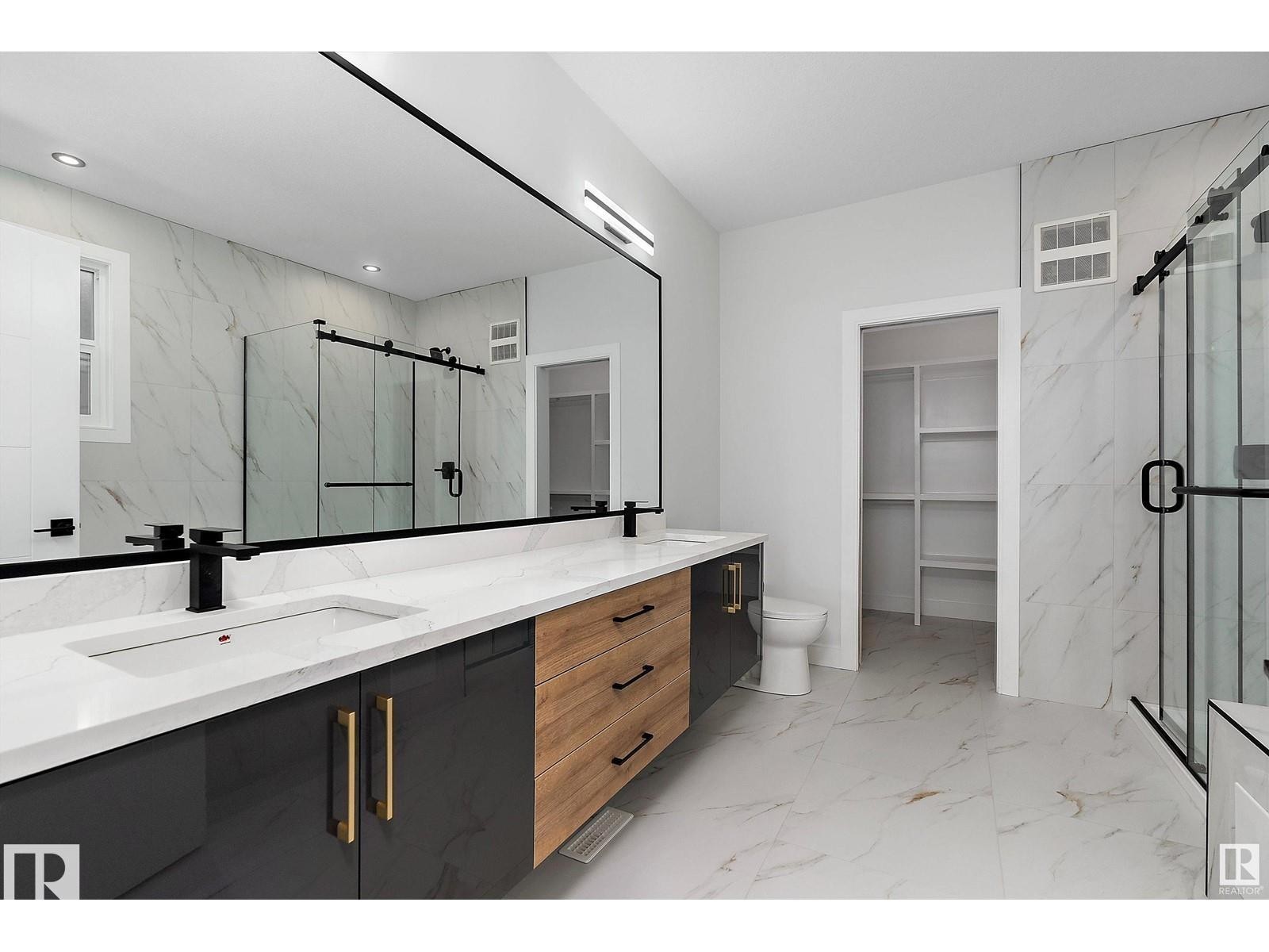Bathroom featuring a walk in closet, double vanity, a marble finish shower, and light marble finish floors - 138 South Ravines Drive, Devon, AB - Indoor Photo Showing Bathroom