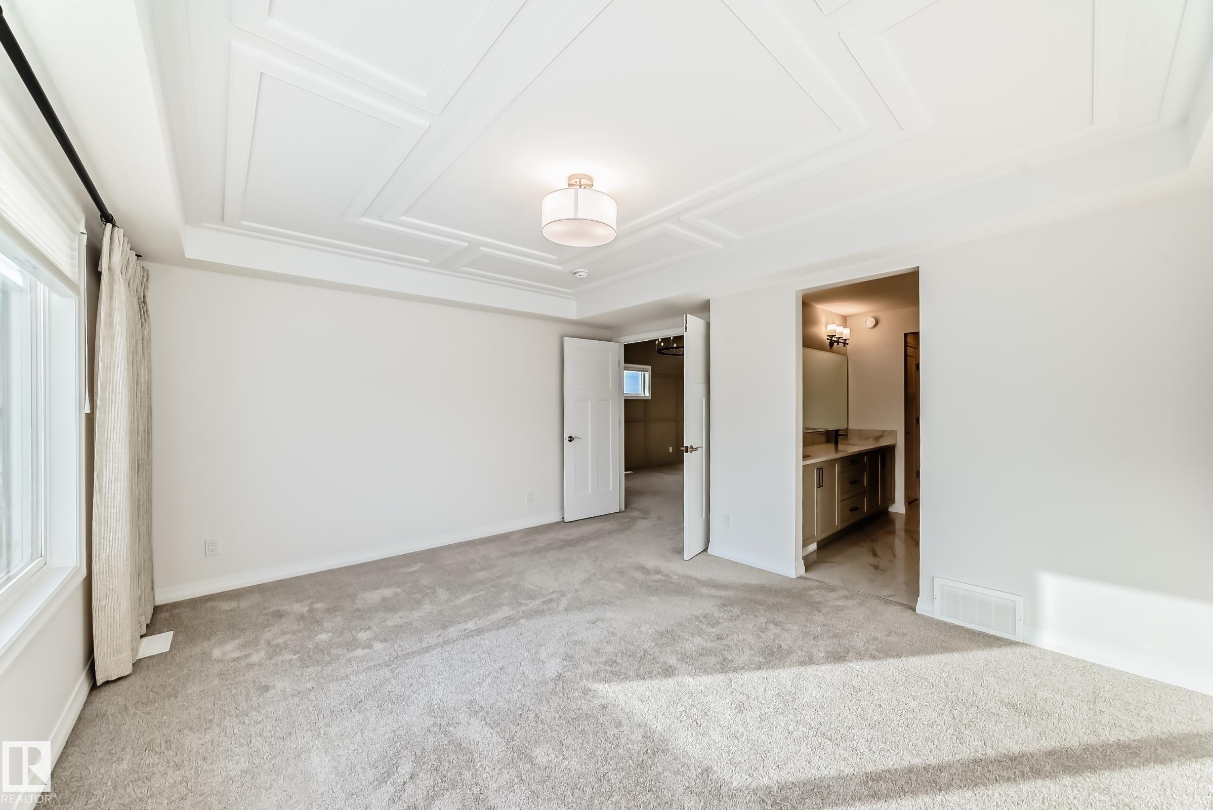 Unfurnished bedroom with light carpet, connected bathroom, and a raised ceiling - 3249 Dixon Way, Edmonton, AB - Indoor Photo Showing Other Room