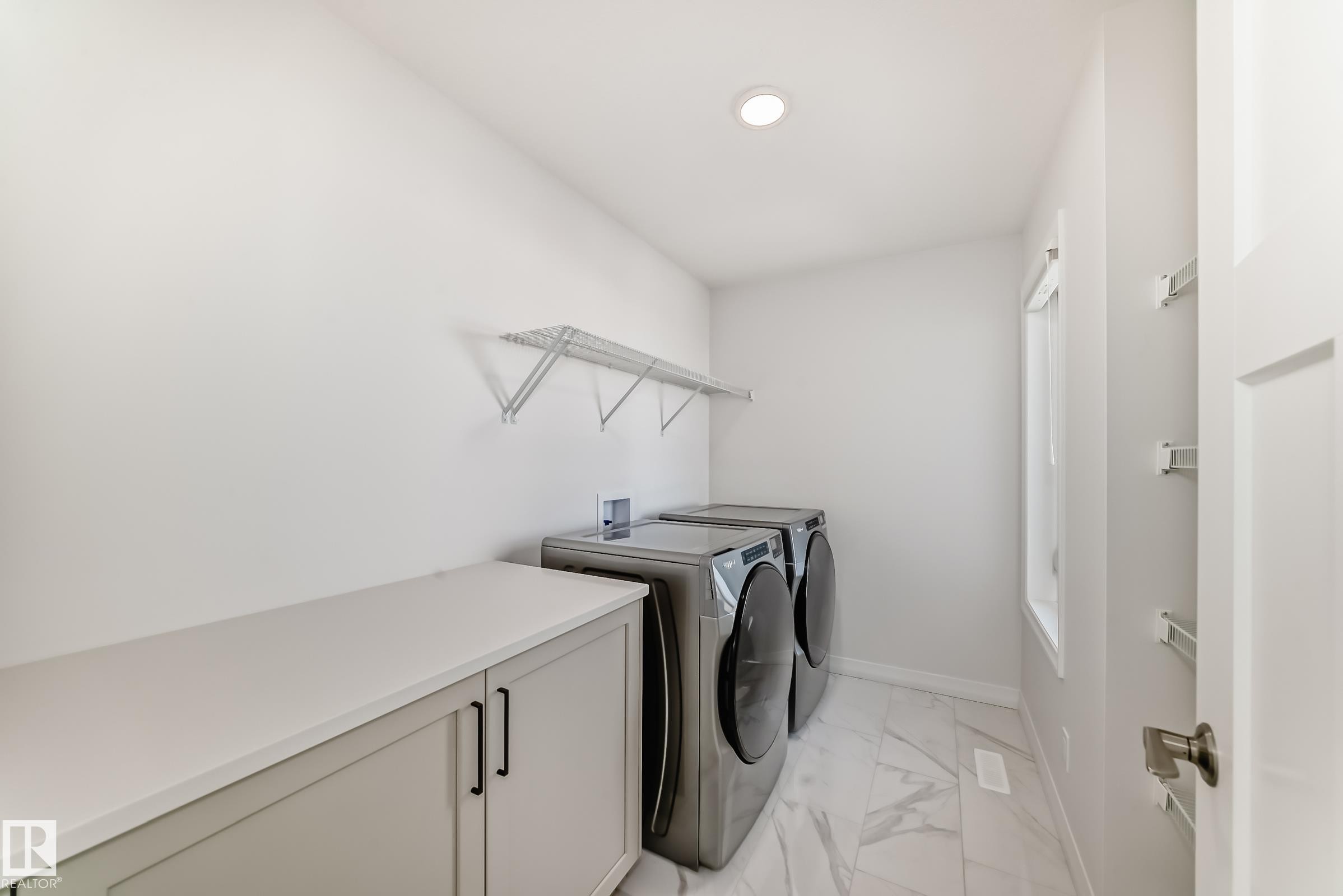 Laundry room with light marble finish floors and separate washer and dryer - 3249 Dixon Way, Edmonton, AB - Indoor Photo Showing Laundry Room