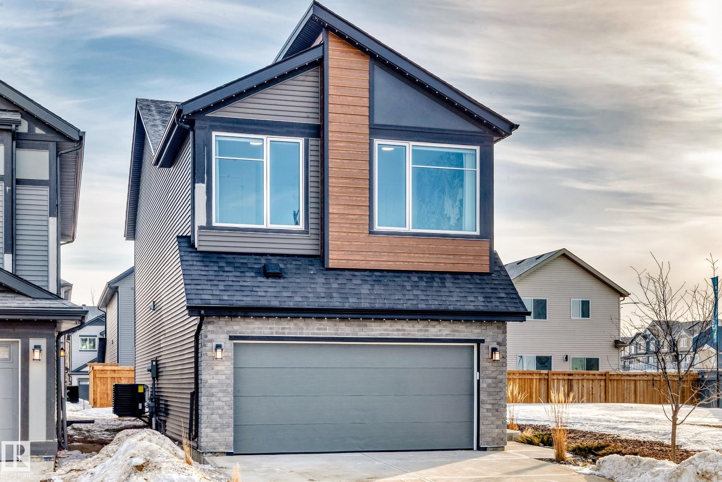 View of front of home featuring a garage, stone siding, a shingled roof, and concrete driveway - 3249 Dixon Way, Edmonton, AB - Outdoor