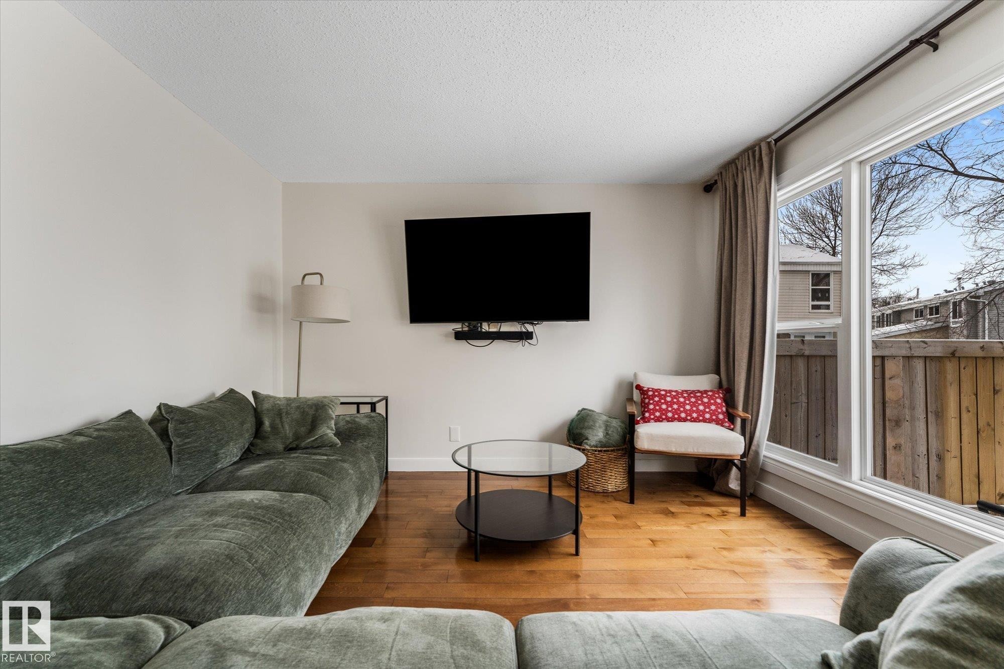 Living room with hardwood / wood-style flooring and a textured ceiling - 289 Grandin Village, St. Albert, AB - Indoor Photo Showing Living Room