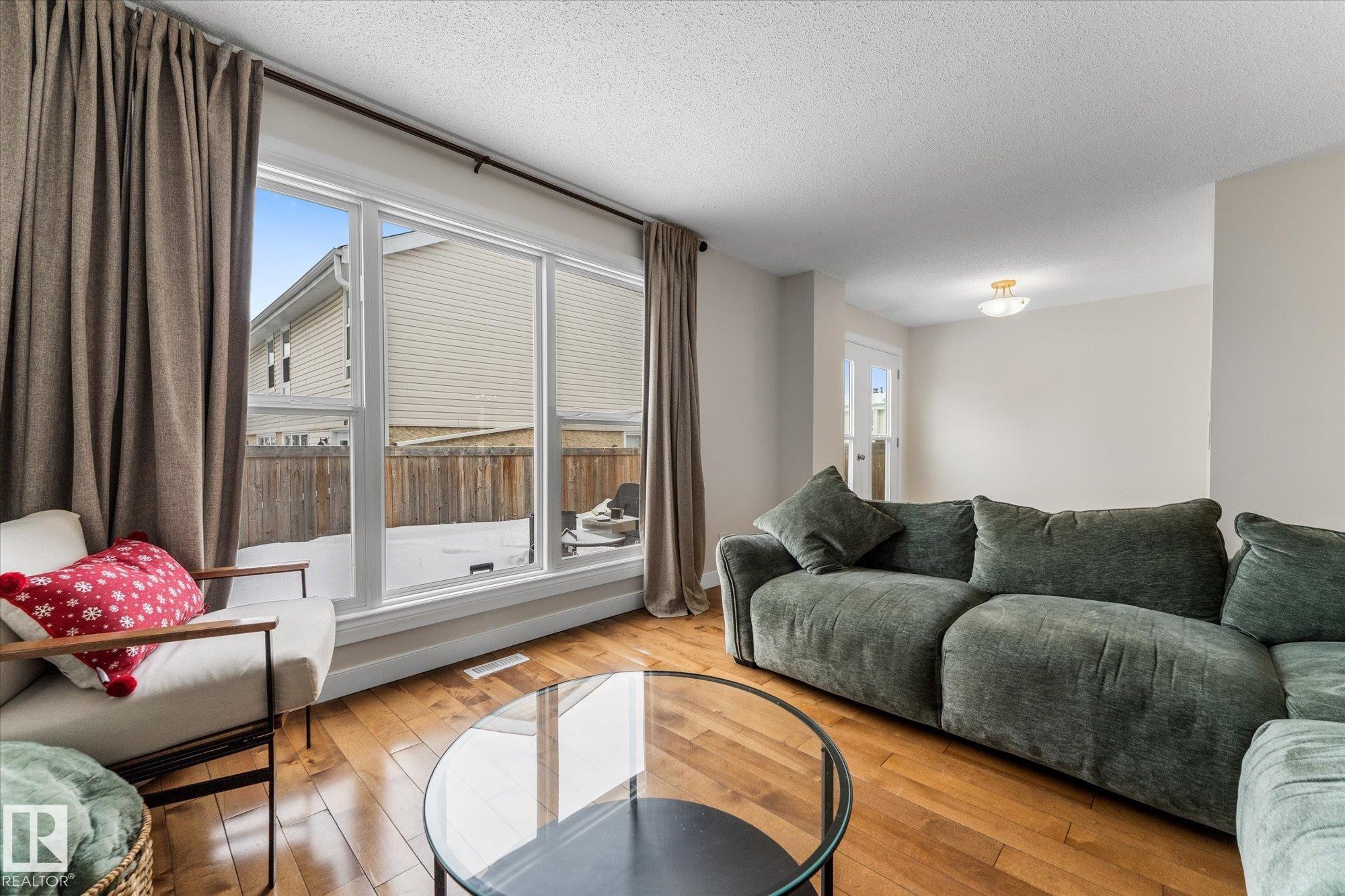 Living area featuring wood-type flooring and a textured ceiling - 289 Grandin Village, St. Albert, AB - Indoor Photo Showing Living Room