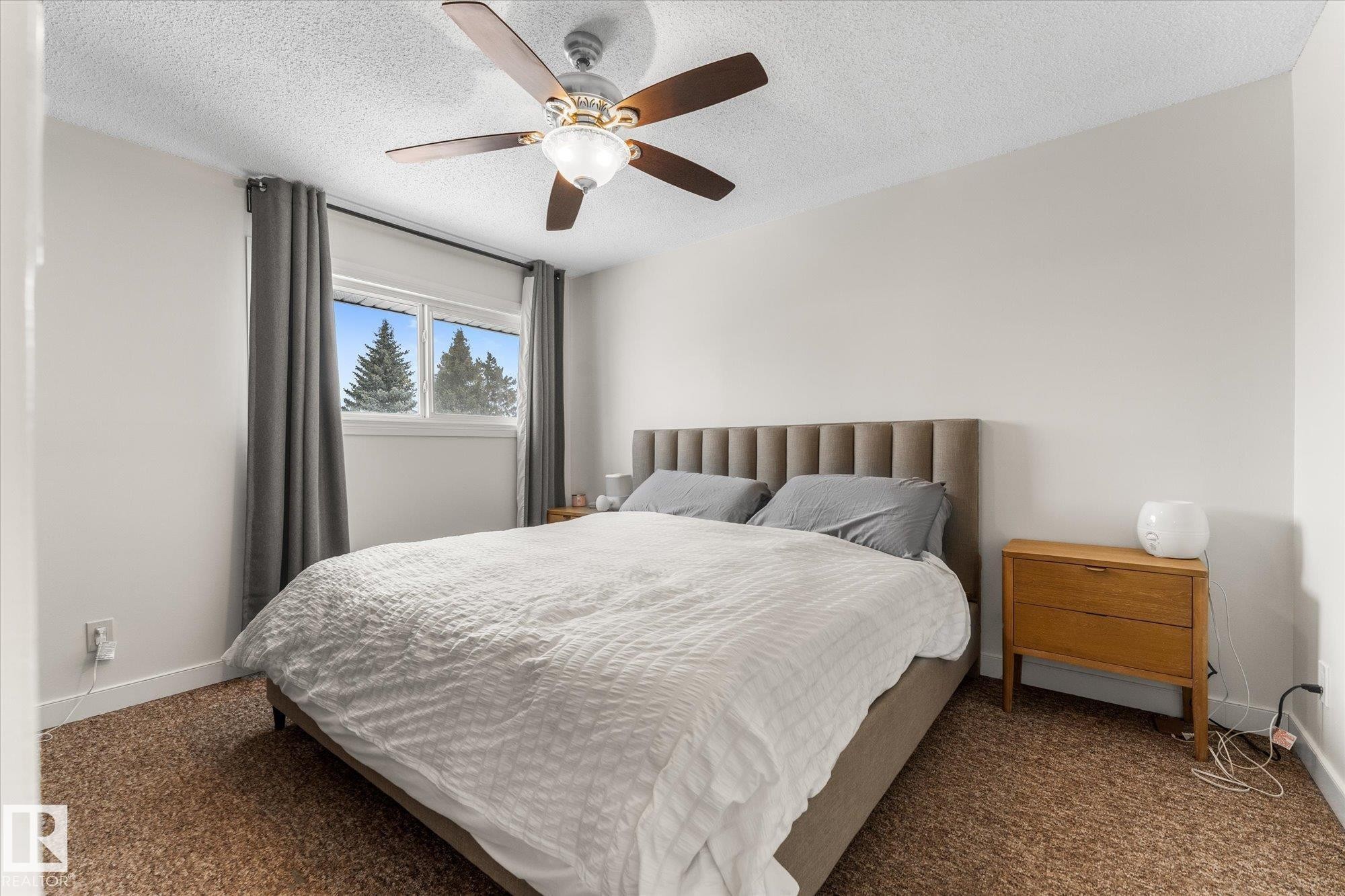 Carpeted bedroom with ceiling fan and a textured ceiling - 289 Grandin Village, St. Albert, AB - Indoor Photo Showing Bedroom