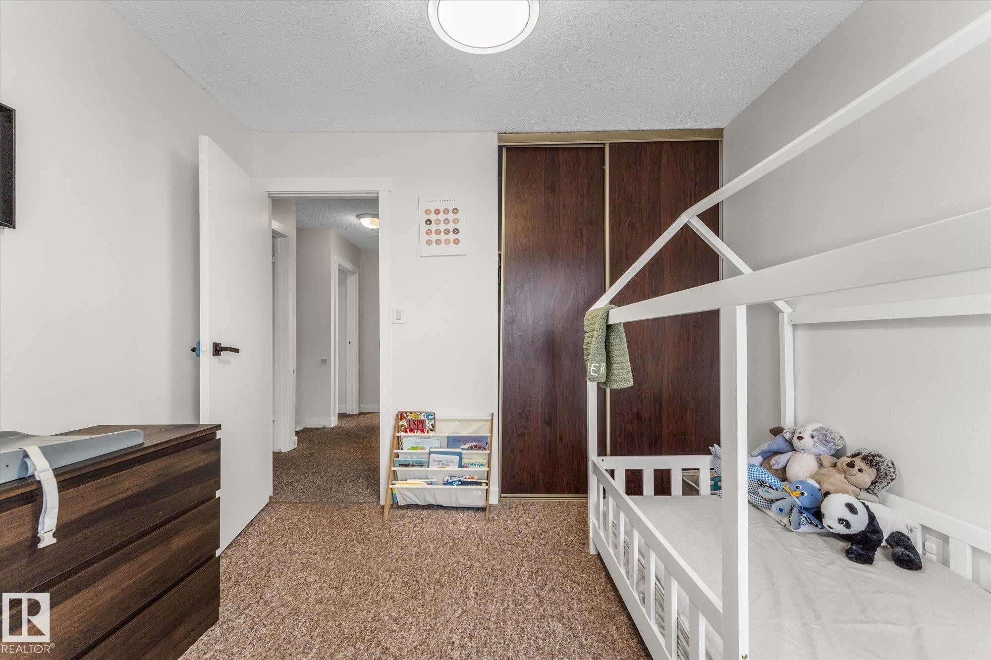 Carpeted bedroom featuring a textured ceiling and a closet - 289 Grandin Village, St. Albert, AB - Indoor Photo Showing Bedroom
