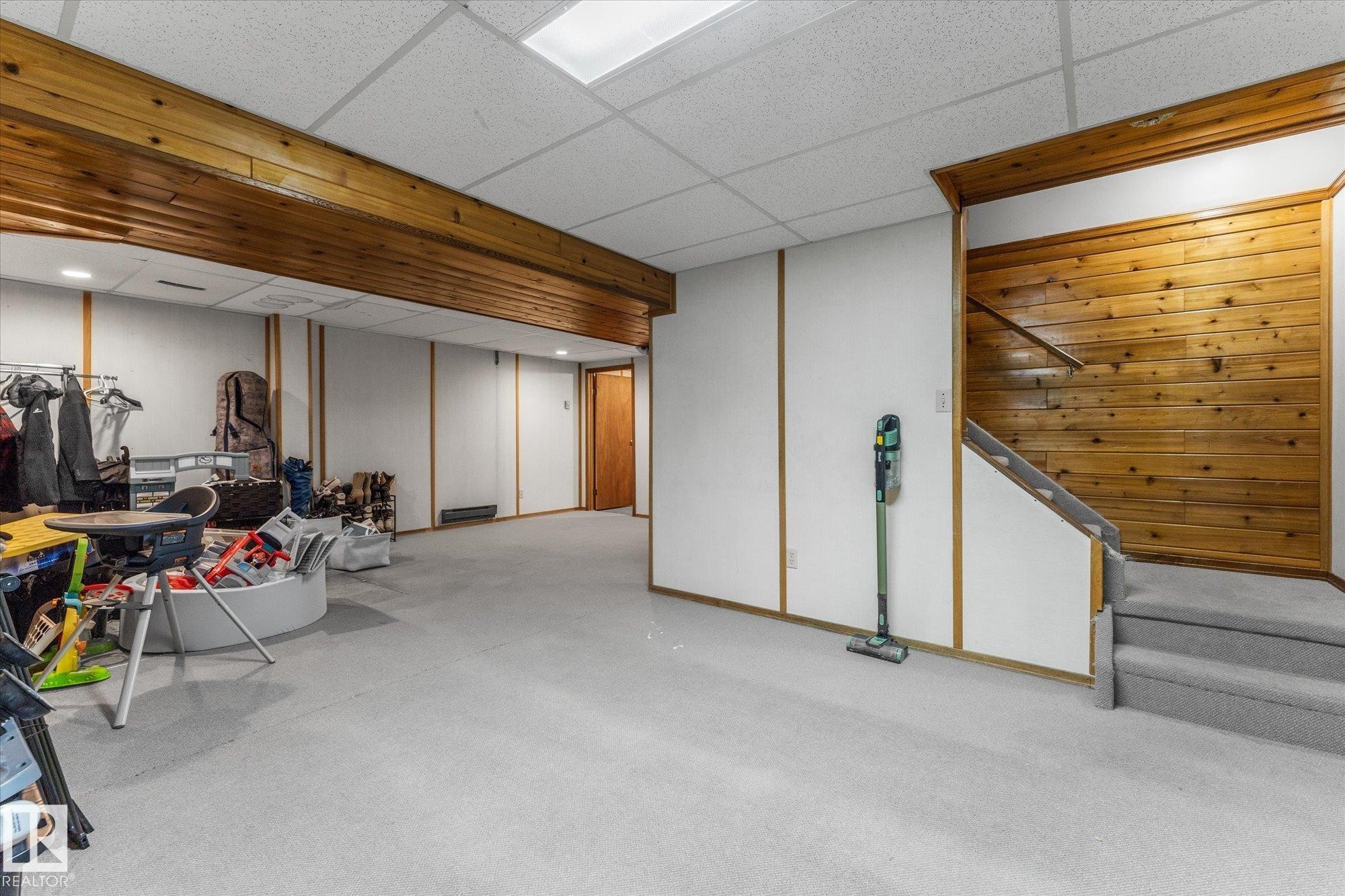 Finished basement featuring a paneled ceiling and stairs - 289 Grandin Village, St. Albert, AB - Indoor