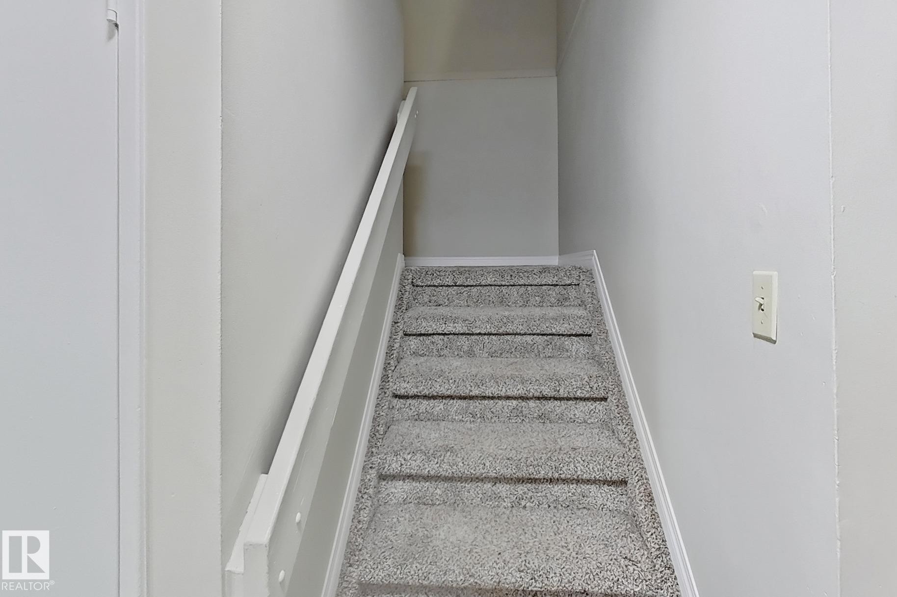 Stairway with baseboards and carpet flooring - 24 3812 20 Avenue, Edmonton, AB - Indoor Photo Showing Other Room