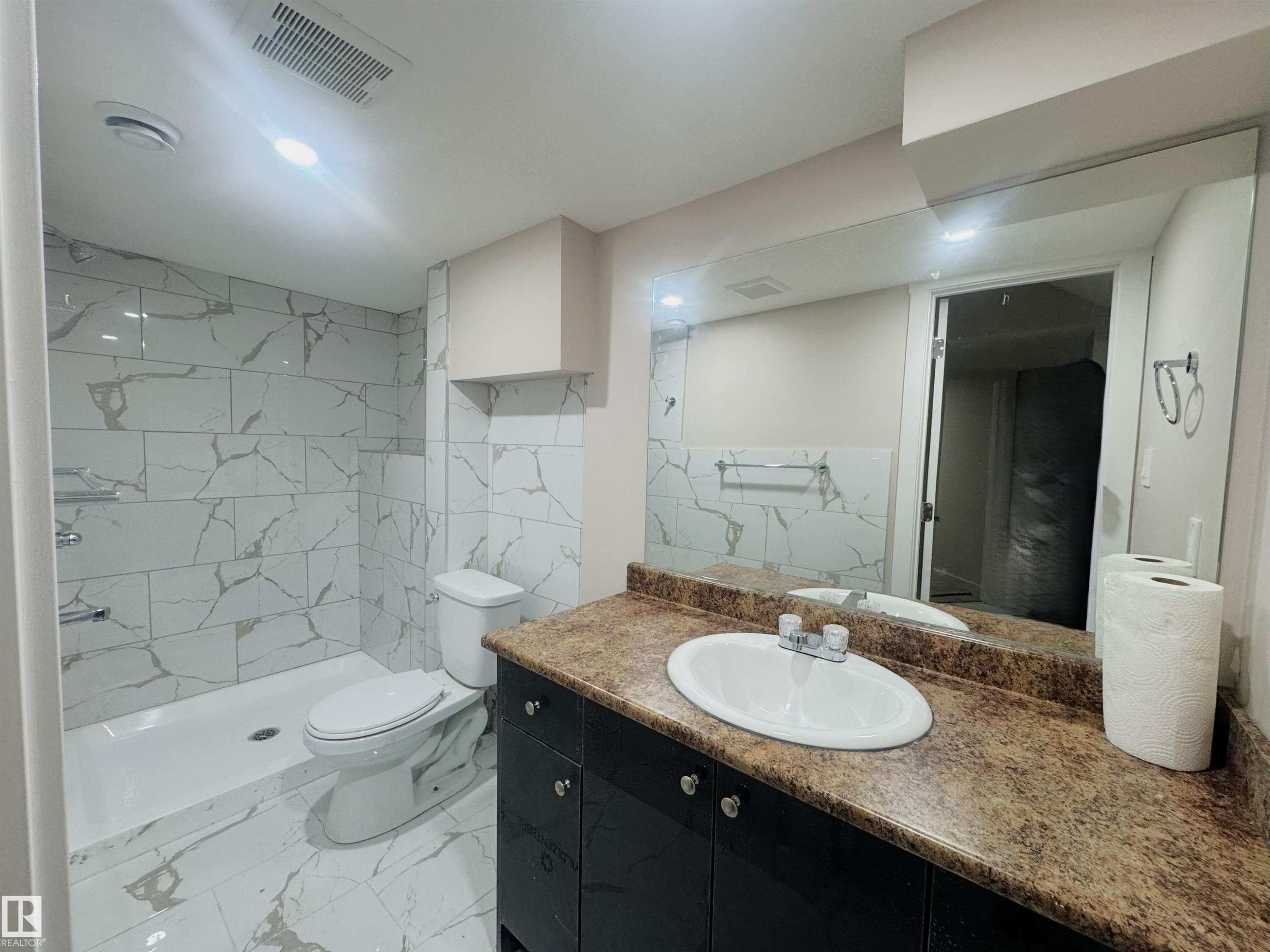 Full bathroom featuring tile walls, vanity, a stall shower, and light marble finish floors - 24 3812 20 Avenue, Edmonton, AB - Indoor Photo Showing Bathroom