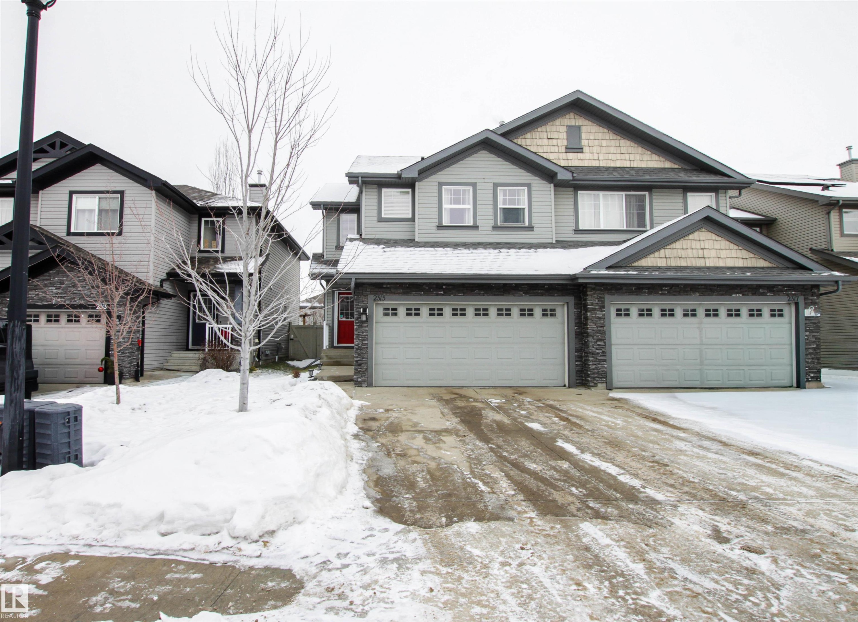 View of front of property featuring stone siding and an attached garage - 2315 Lemieux Place, Edmonton, AB - Outdoor With Facade