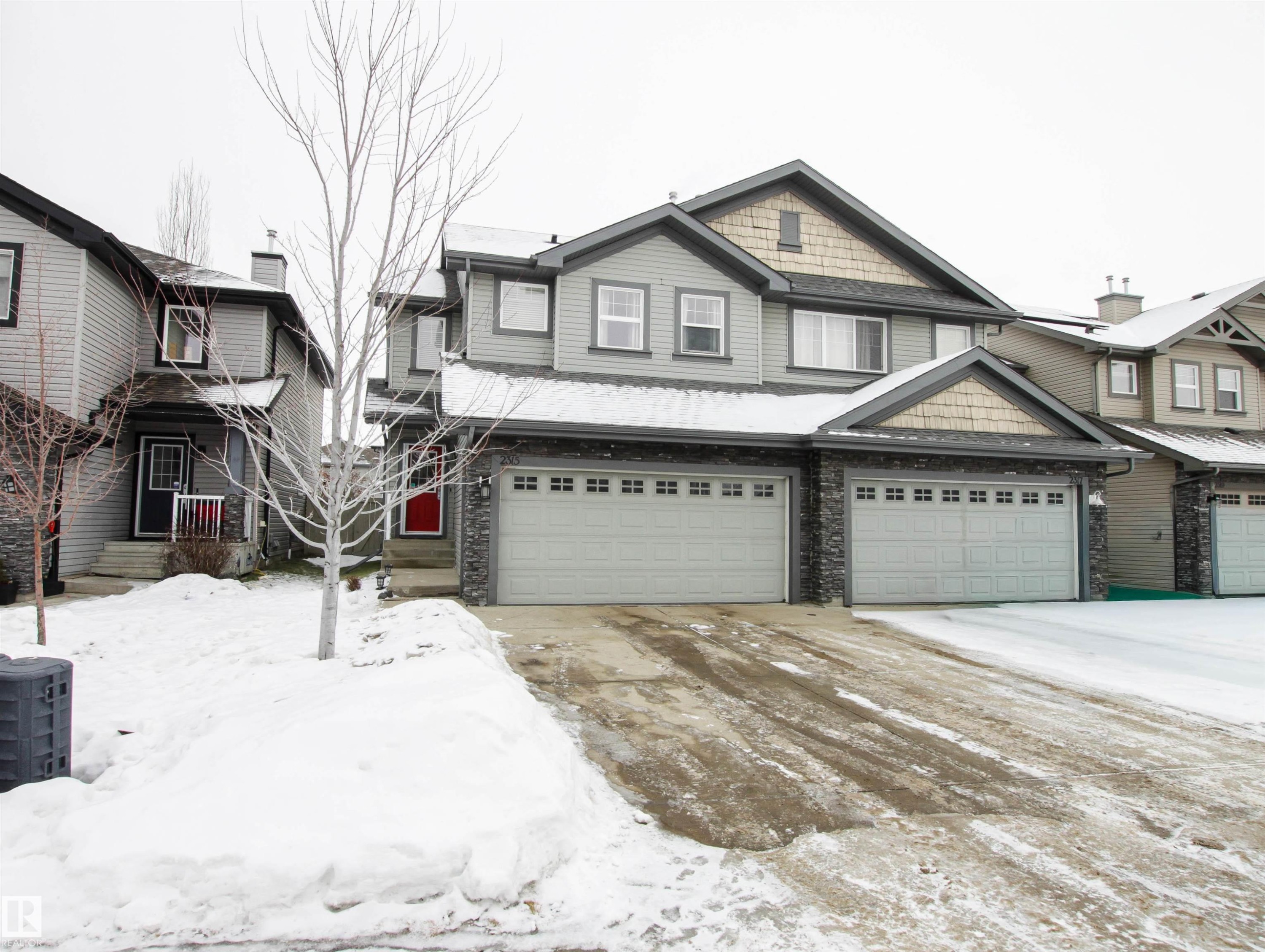 View of front of property with stone siding and a garage - 2315 Lemieux Place, Edmonton, AB - Outdoor With Facade