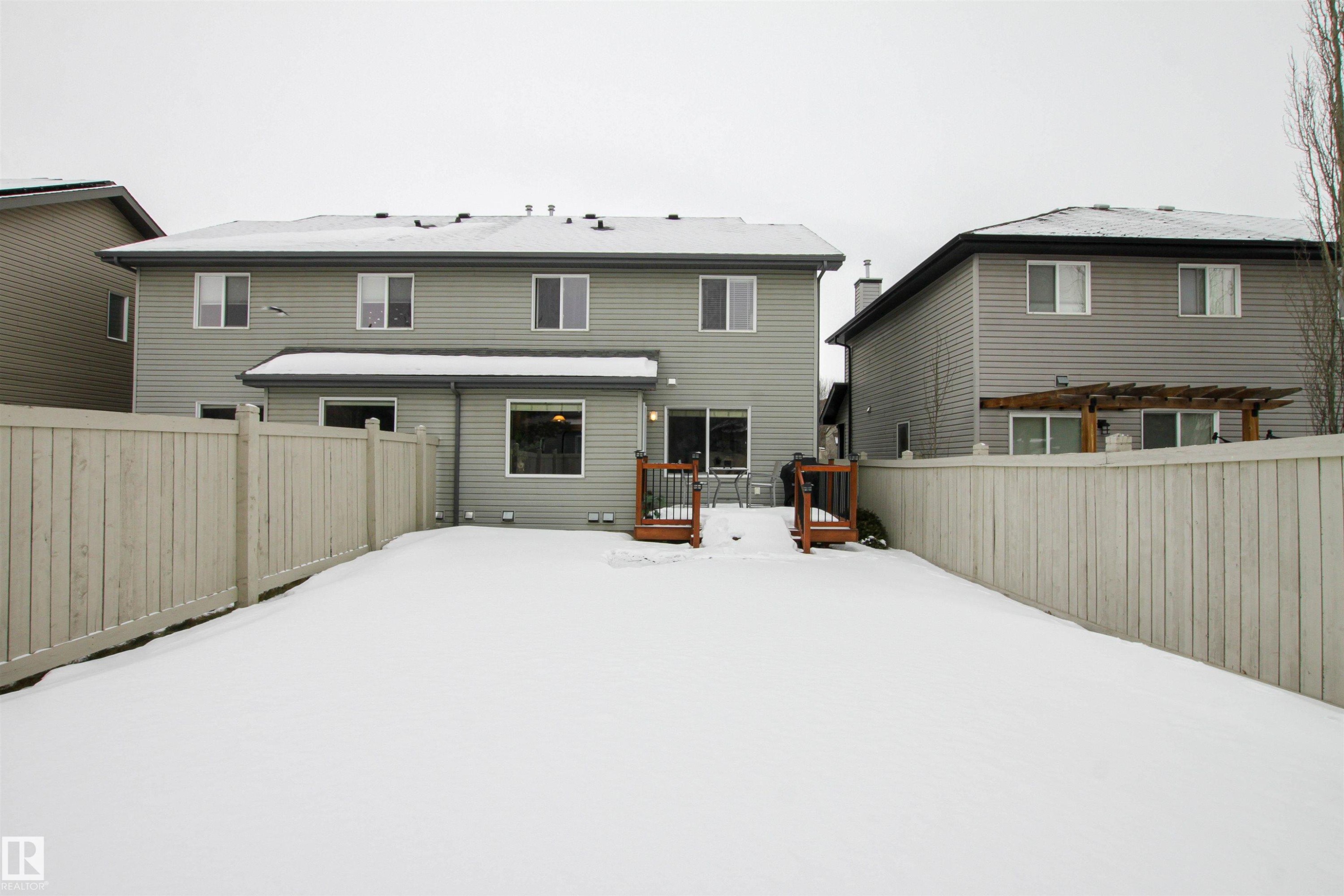 Snow covered house featuring a wooden deck and a fenced backyard - 2315 Lemieux Place, Edmonton, AB - Outdoor With Exterior