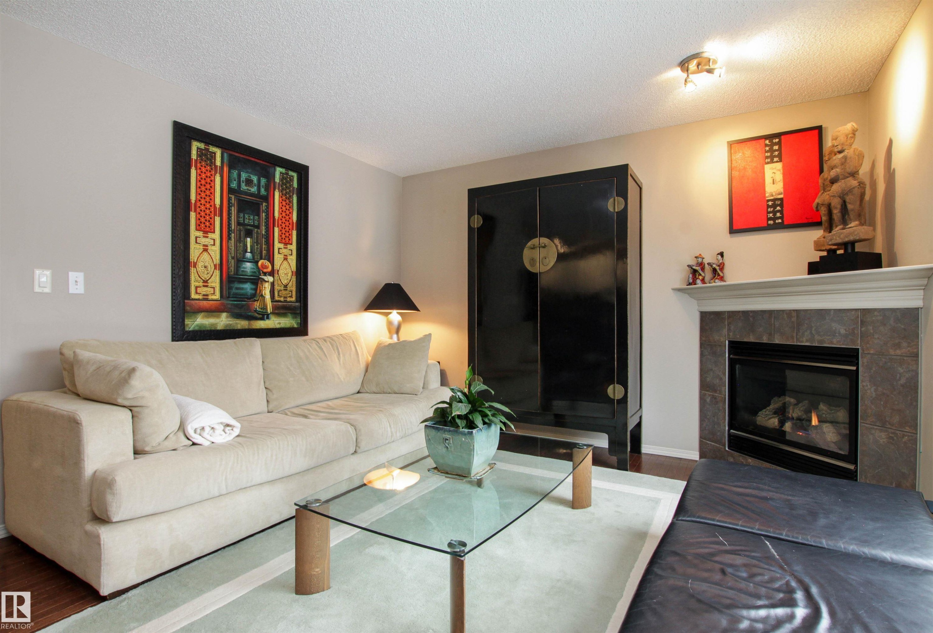 Living room with a textured ceiling, wood finished floors, and a fireplace - 2315 Lemieux Place, Edmonton, AB - Indoor Photo Showing Living Room With Fireplace