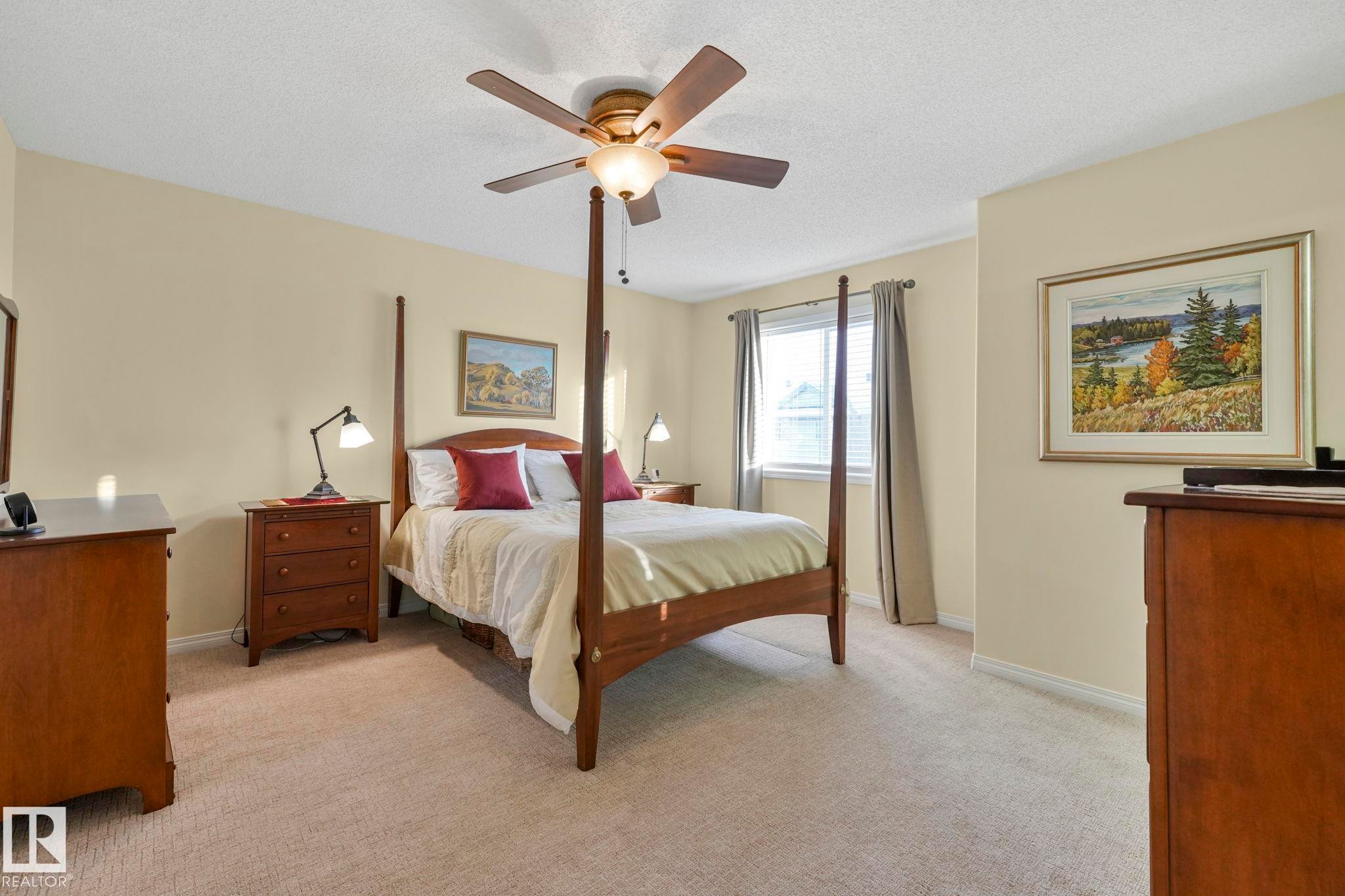 Bedroom featuring light carpet, ceiling fan, and a textured ceiling - 23 4755 Terwillegar Common, Edmonton, AB - Indoor Photo Showing Bedroom